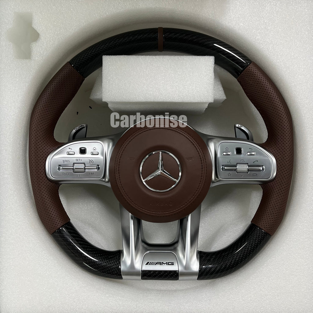 Custom Mercedes-Benz AMG steering wheel featuring gloss carbon fiber, premium brown perforated leather side grips, and integrated silver roller controls.