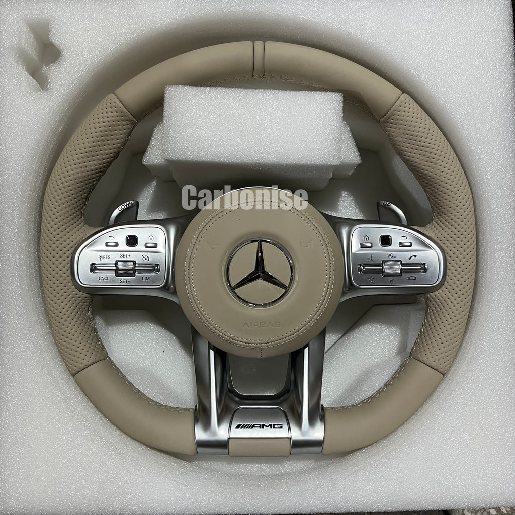 Custom Mercedes-Benz AMG steering wheel featuring a full cream-colored leather wrap with perforated side grips and integrated silver performance controls.