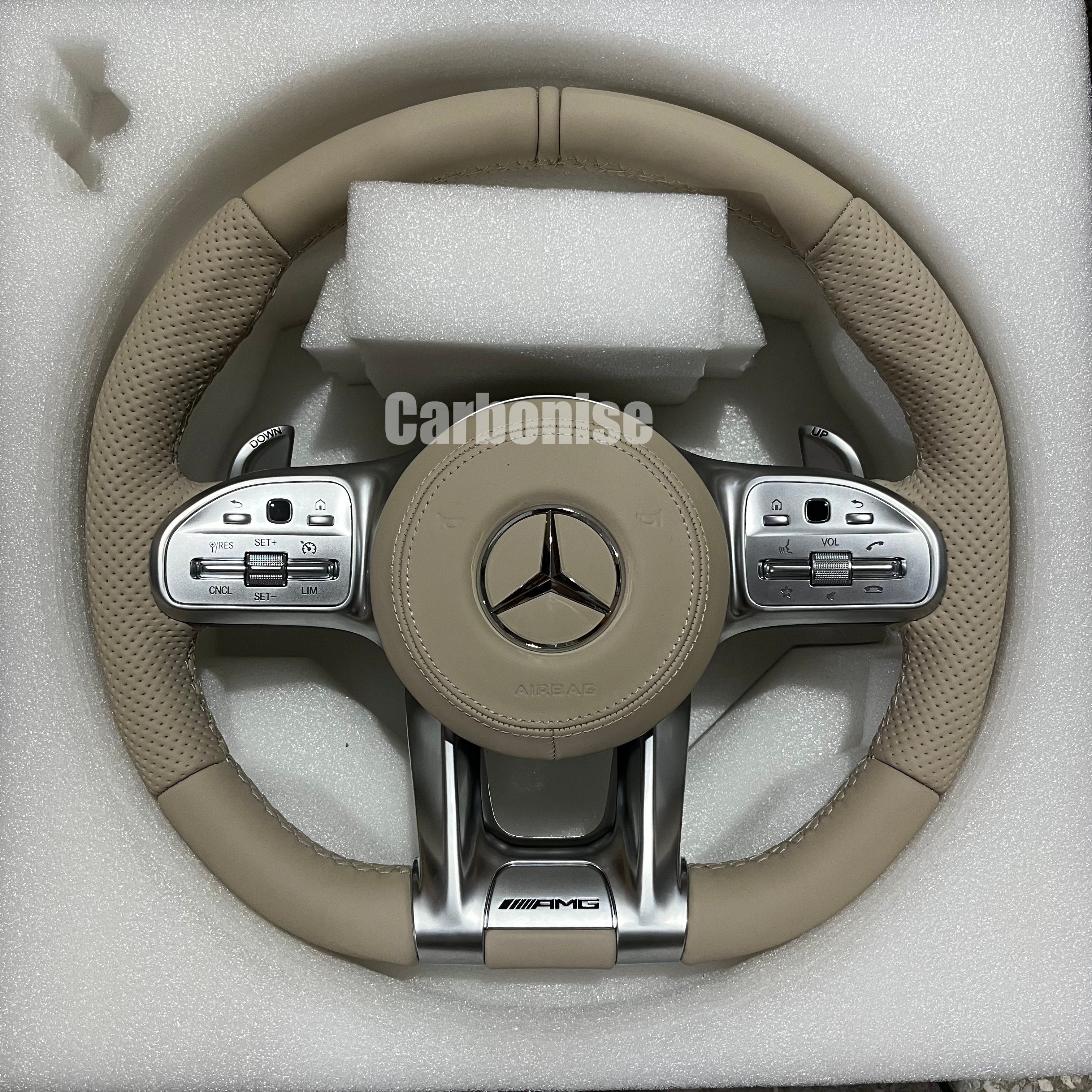 Custom Mercedes-Benz AMG steering wheel featuring a full cream-colored leather wrap with perforated side grips and integrated silver performance controls.