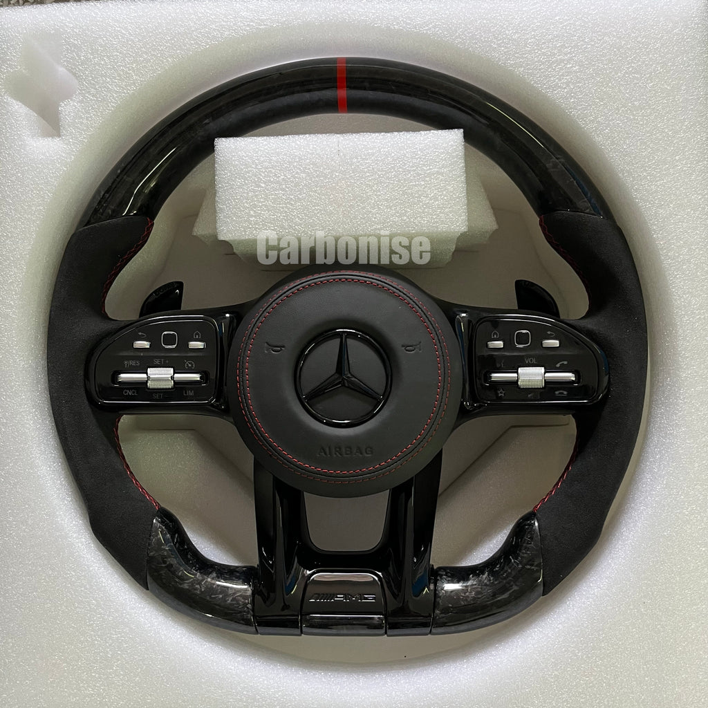 Custom Mercedes-Benz AMG steering wheel featuring high-gloss carbon fiber, a red top racing stripe, and black Alcantara side grips with red stitching.