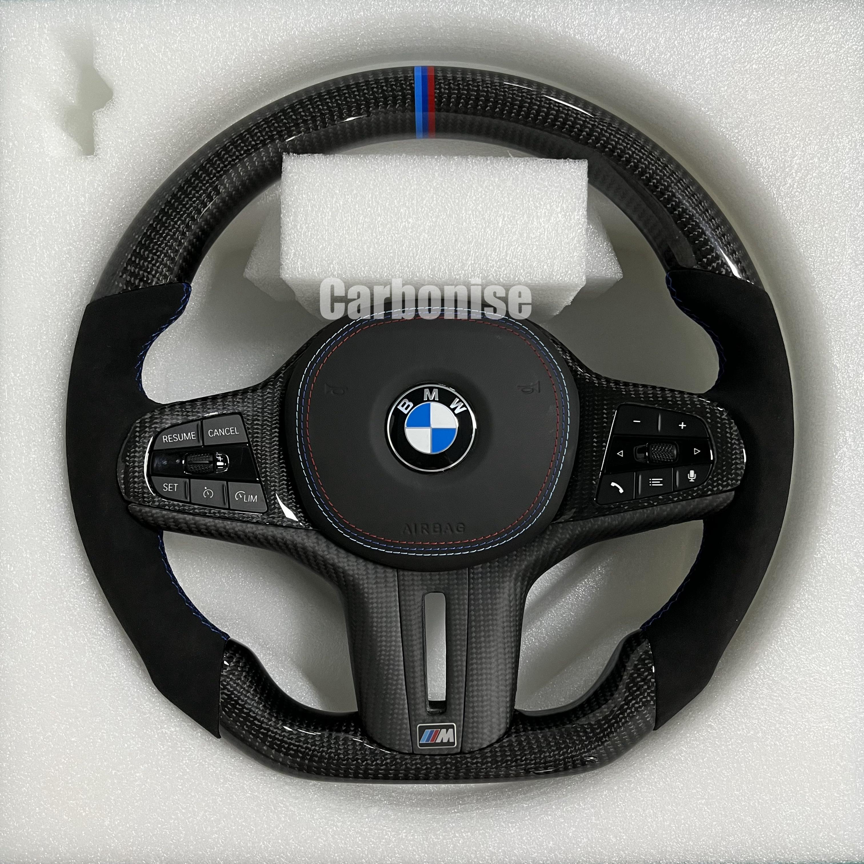 Custom BMW M performance steering wheel featuring high-gloss carbon fiber, premium black Alcantara side grips, and a signature M-tri color top racing stripe.