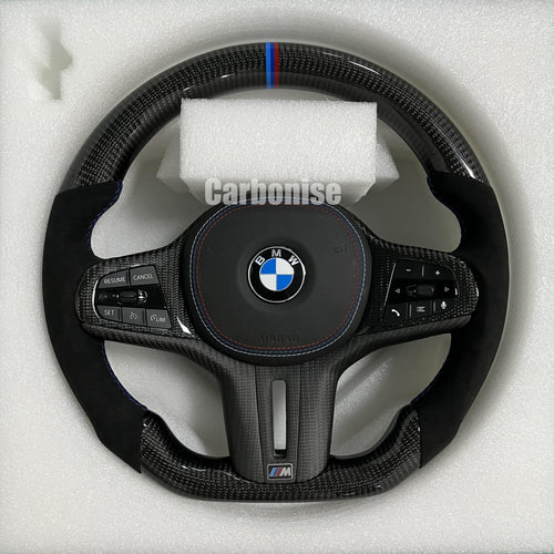 Custom BMW M performance steering wheel featuring high-gloss carbon fiber, premium black Alcantara side grips, and a signature M-tri color top racing stripe.