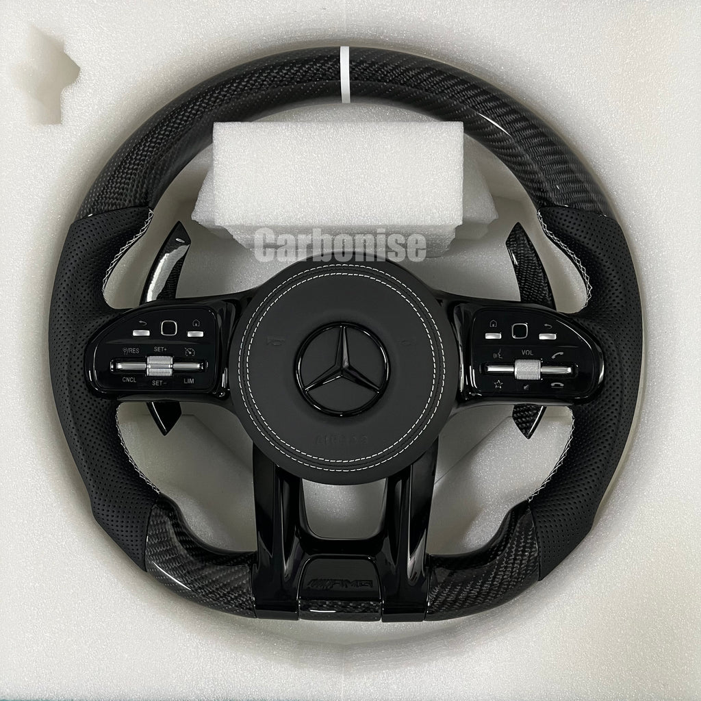 Custom Mercedes-Benz AMG performance steering wheel featuring gloss carbon fiber, a digital LED display, and black perforated leather side grips.