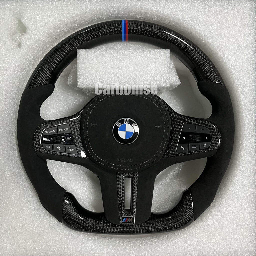 Custom BMW M performance steering wheel featuring high-gloss carbon fiber, black Alcantara side grips, and a signature M-tri color top racing stripe.