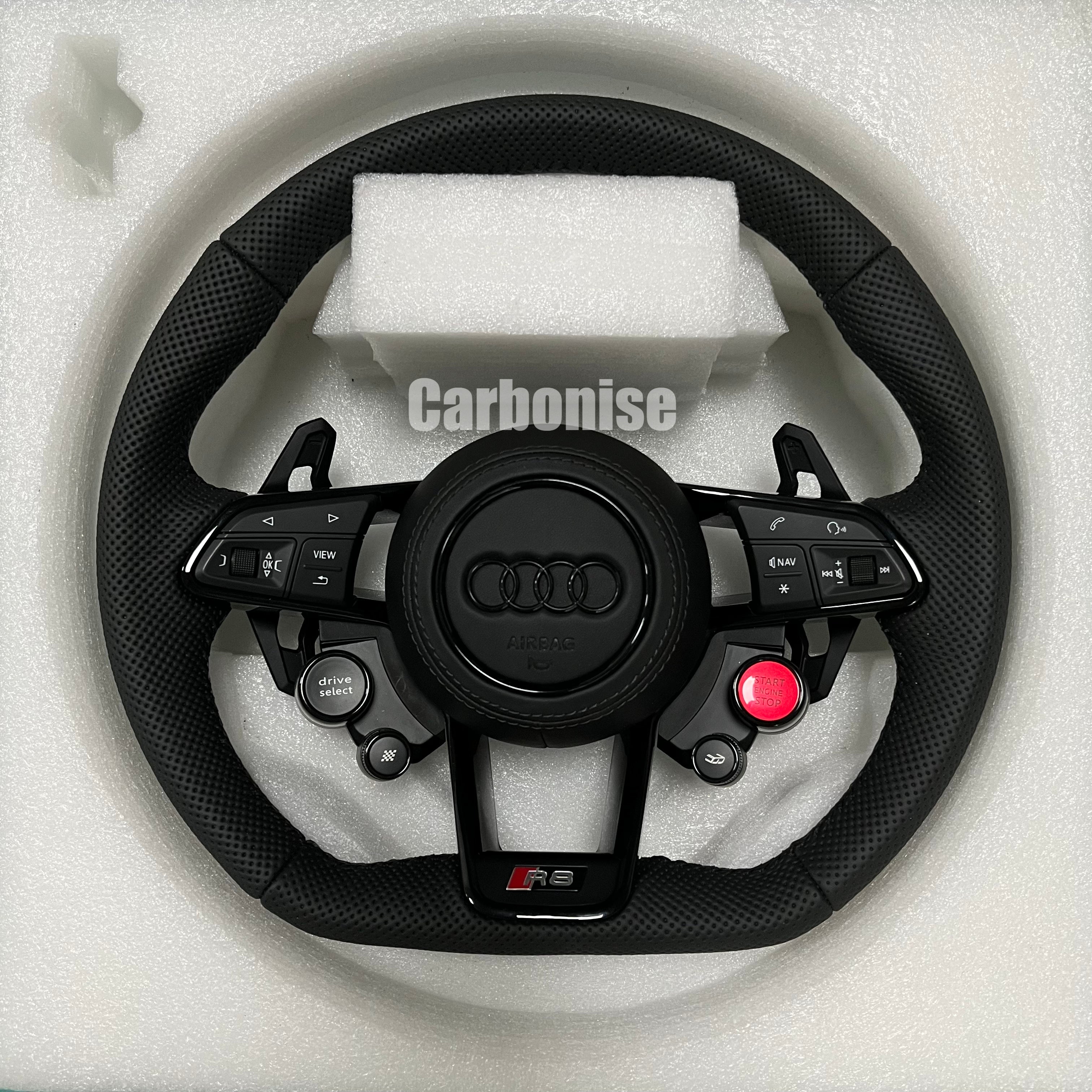 Custom Audi R8 performance steering wheel featuring full perforated leather grips, integrated red Start/Stop button, and Drive Select controls with a blacked-out center emblem.