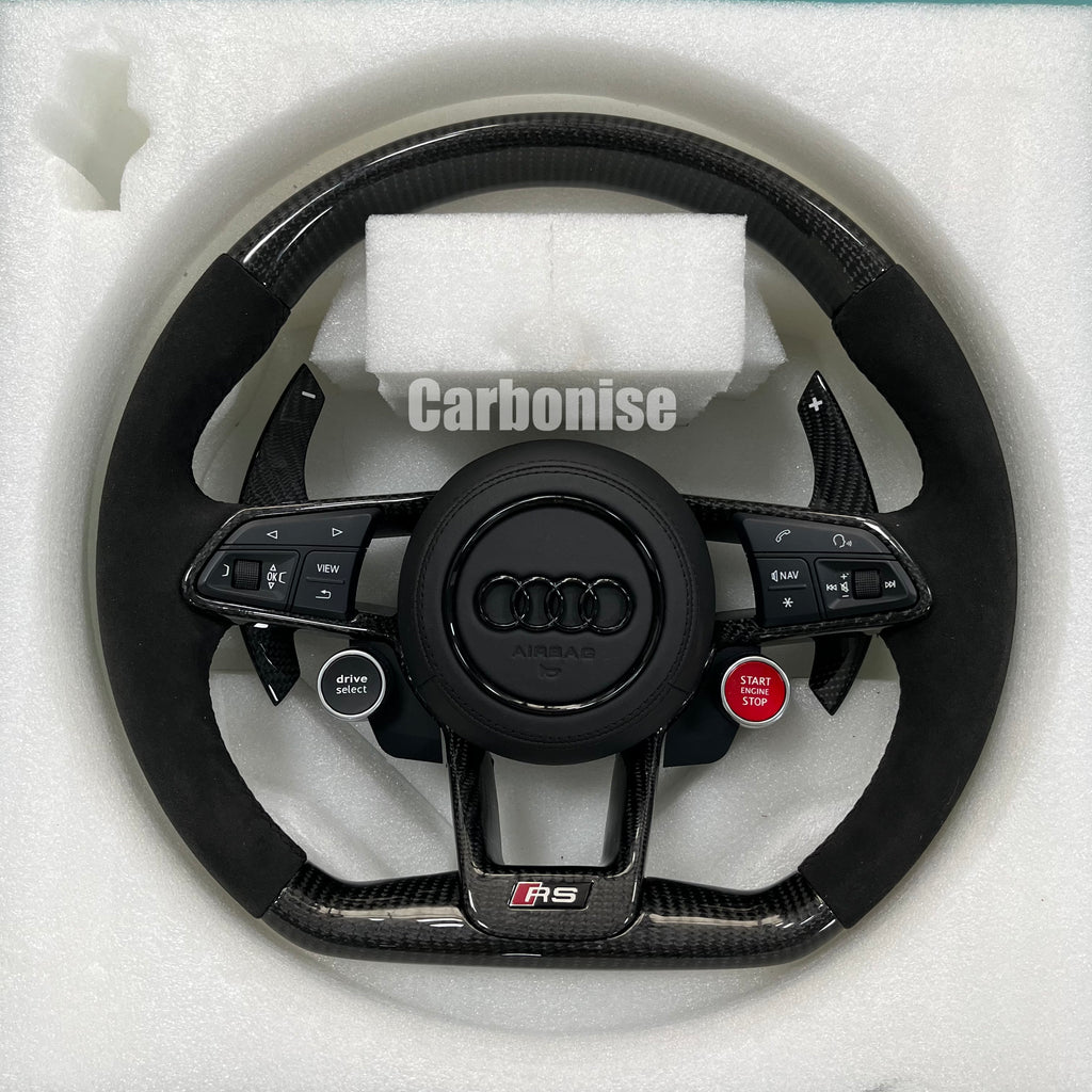 Custom Audi RS carbon fiber steering wheel featuring integrated red Start/Stop and black Drive Select buttons, premium black Alcantara side grips, and carbon fiber paddle shifters.