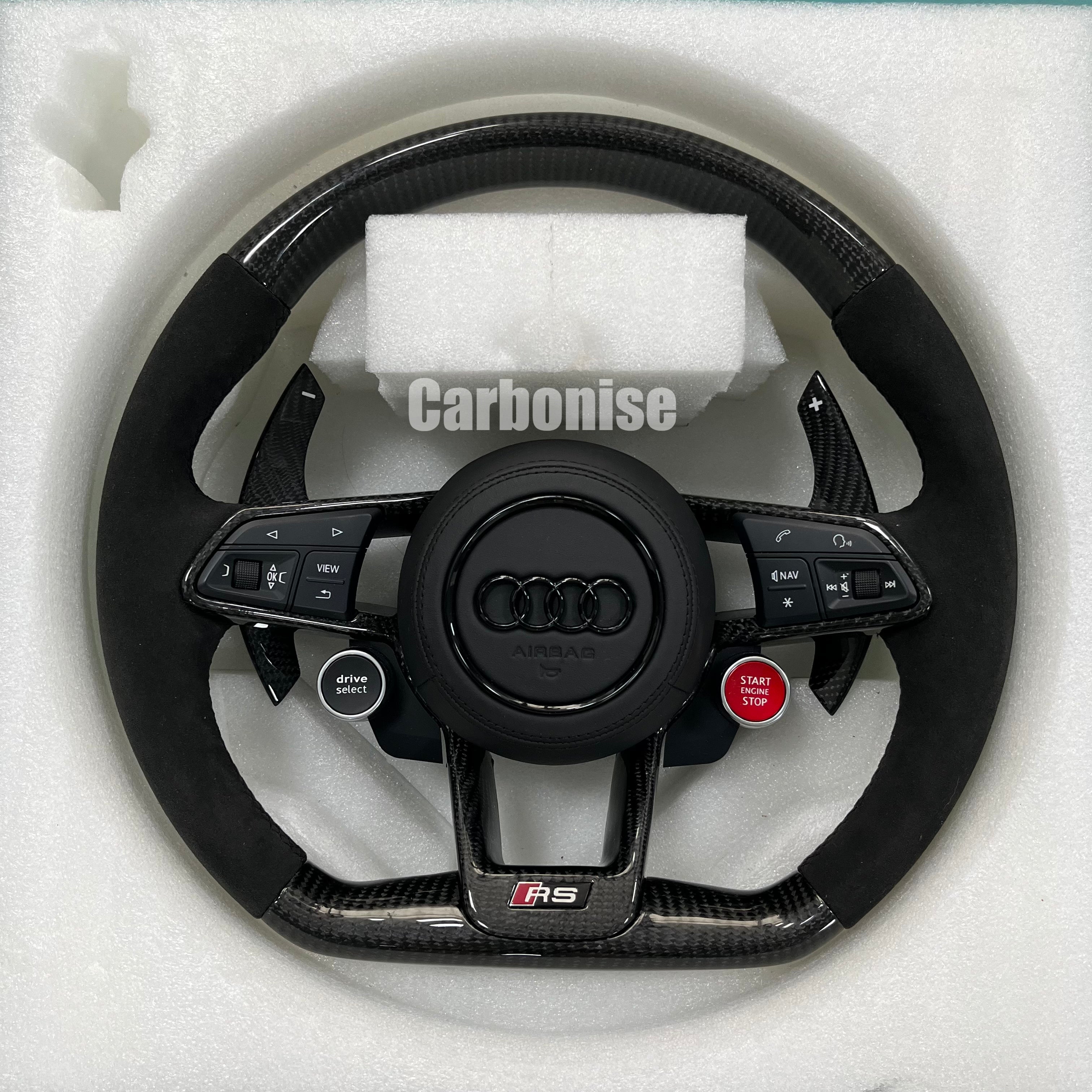 Custom Audi RS carbon fiber steering wheel featuring integrated red Start/Stop and black Drive Select buttons, premium black Alcantara side grips, and carbon fiber paddle shifters.