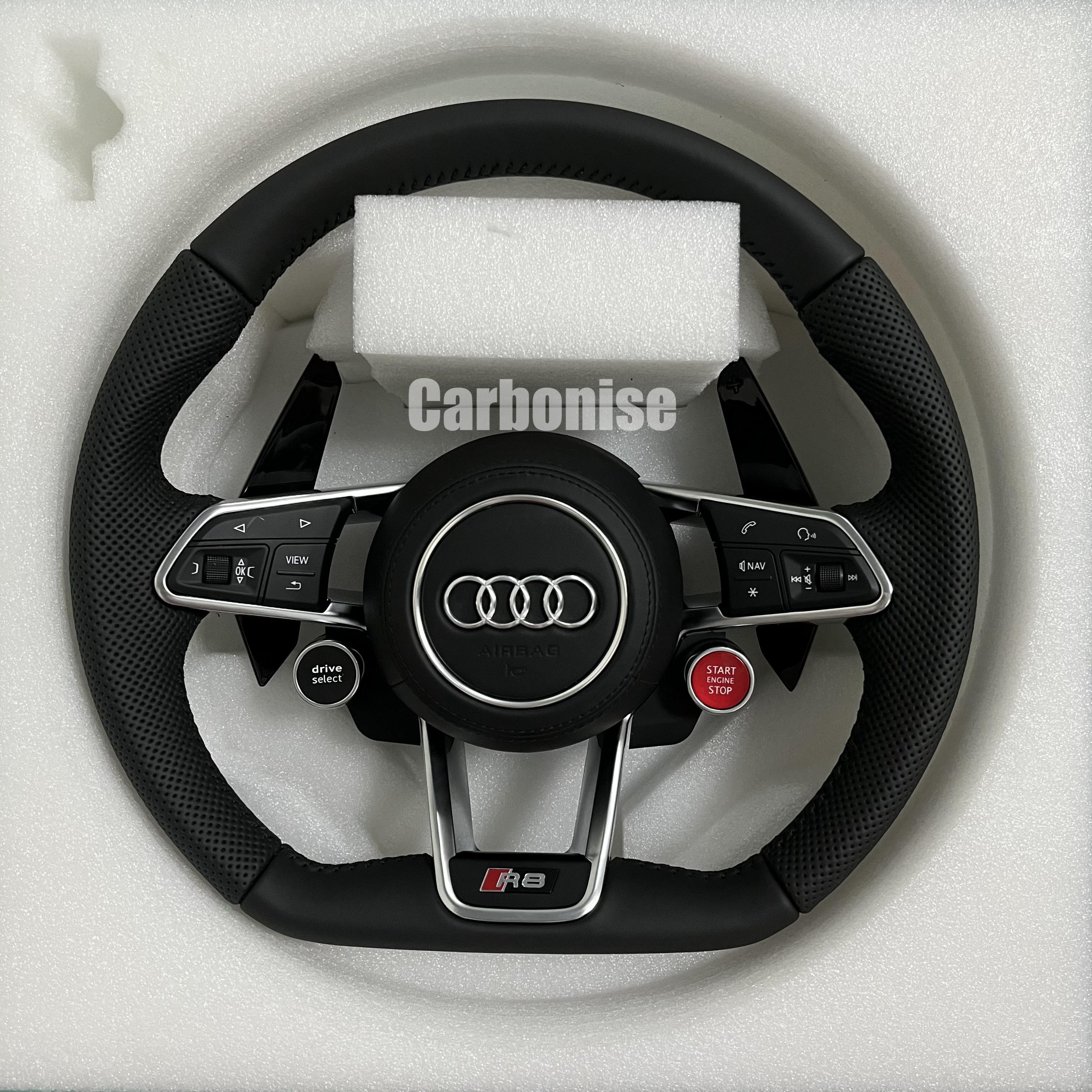 Custom Audi R8 performance steering wheel featuring full black perforated leather grips, integrated red Start/Stop and black Drive Select buttons, and a silver-trimmed airbag cover with the Audi rings emblem.