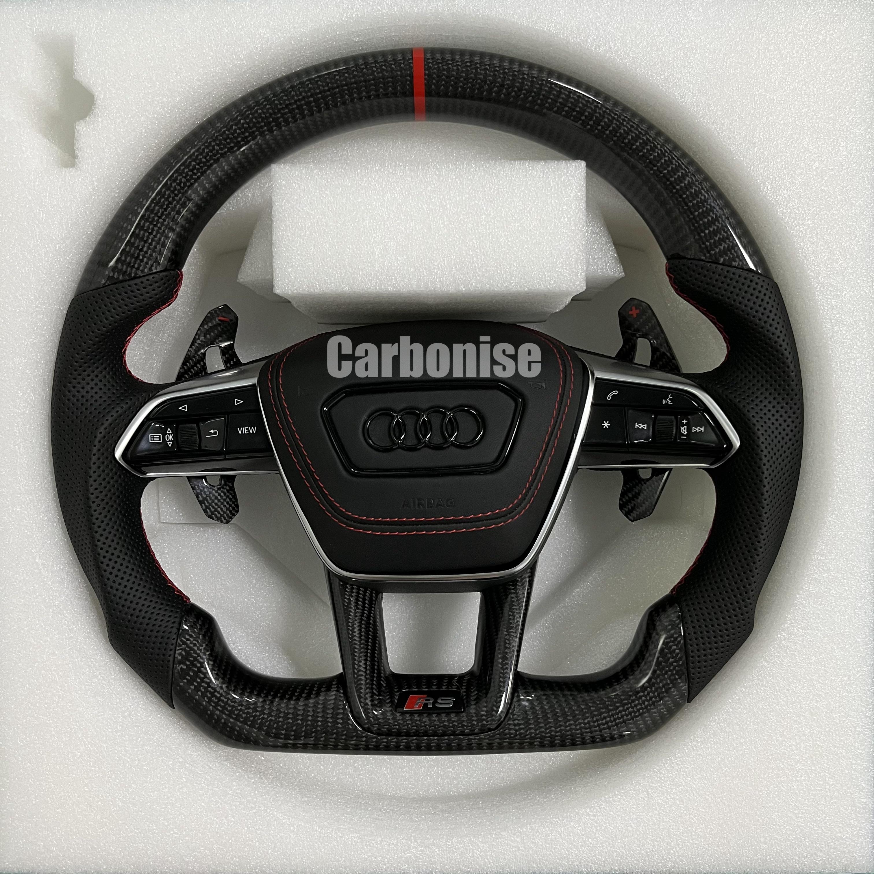 Custom Audi RS steering wheel with high-gloss carbon fiber, a red top racing stripe, and black perforated leather side grips with red stitching.