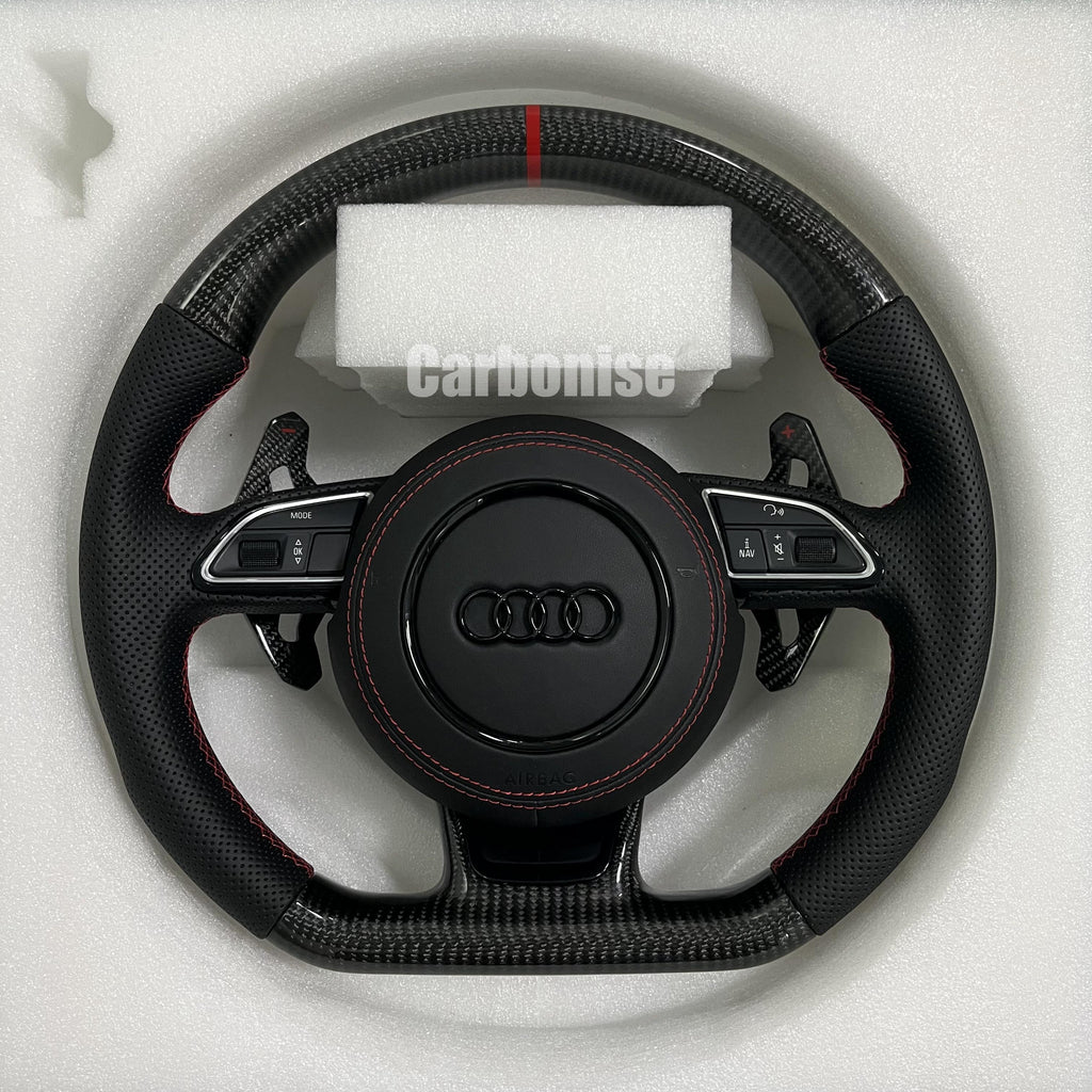 Audi carbon fiber flat-bottom steering wheel with red centre stripe, red stitching, perforated leather grips, paddle shifter and multifunction buttons.