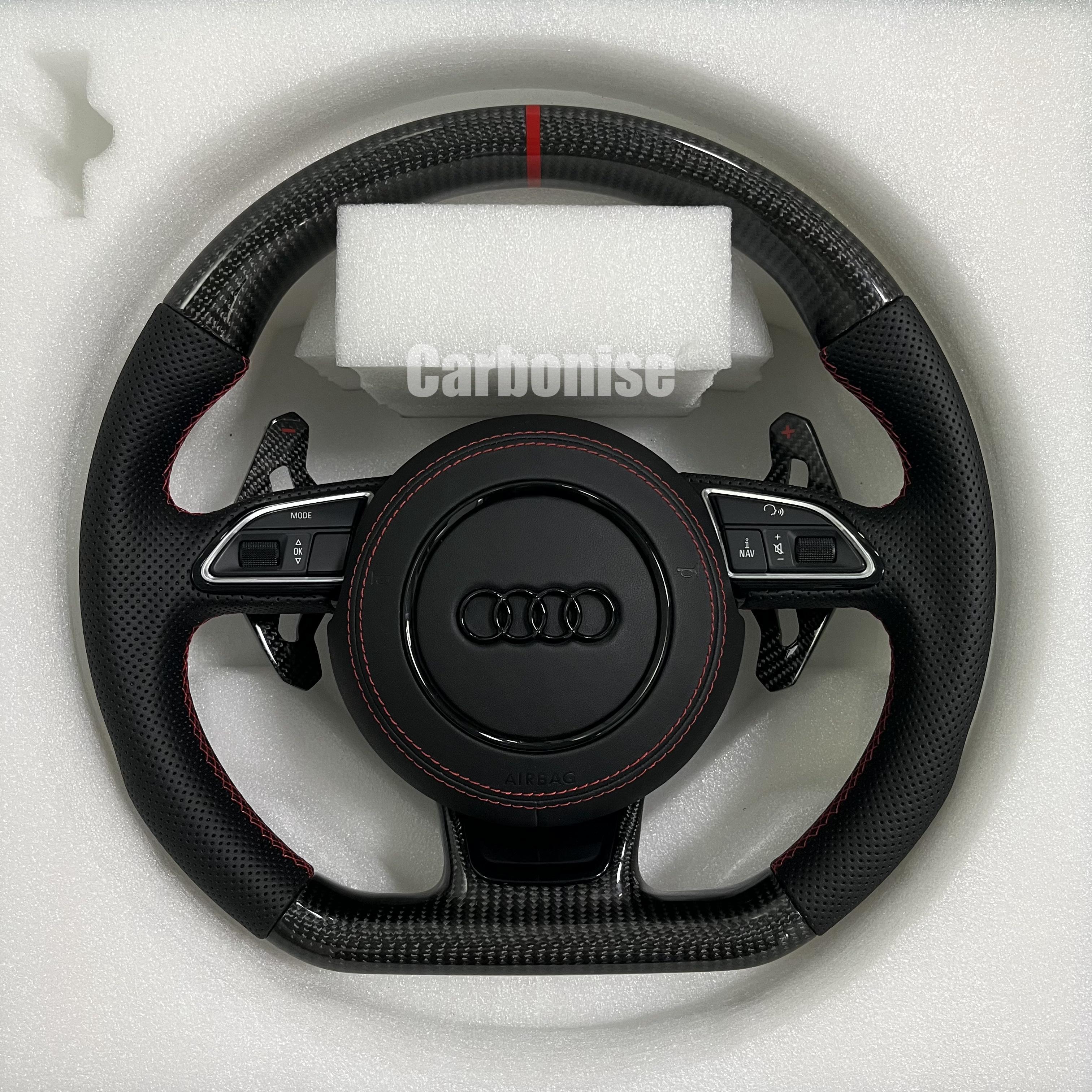 Audi carbon fiber flat-bottom steering wheel with red centre stripe, red stitching, perforated leather grips, paddle shifter and multifunction buttons.