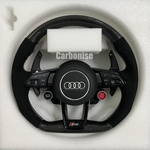 Custom Audi R8 carbon fiber steering wheel featuring black Alcantara side grips, integrated red Start/Stop and black Drive Select buttons, and white contrast stitching.