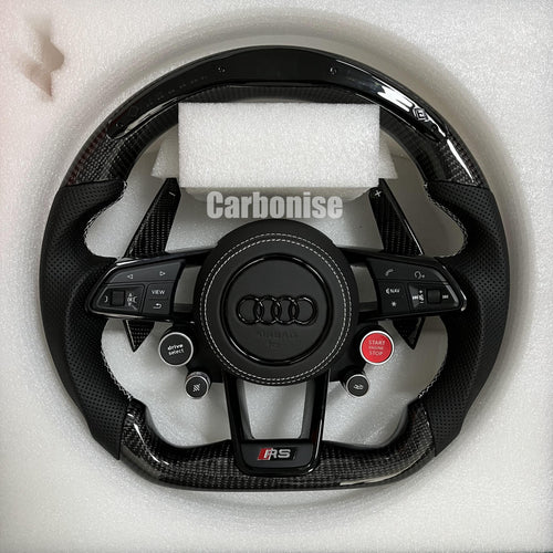 Custom Audi RS steering wheel featuring gloss carbon fiber, perforated leather grips with white stitching, integrated R8 performance buttons, and carbon fiber paddle shifters.