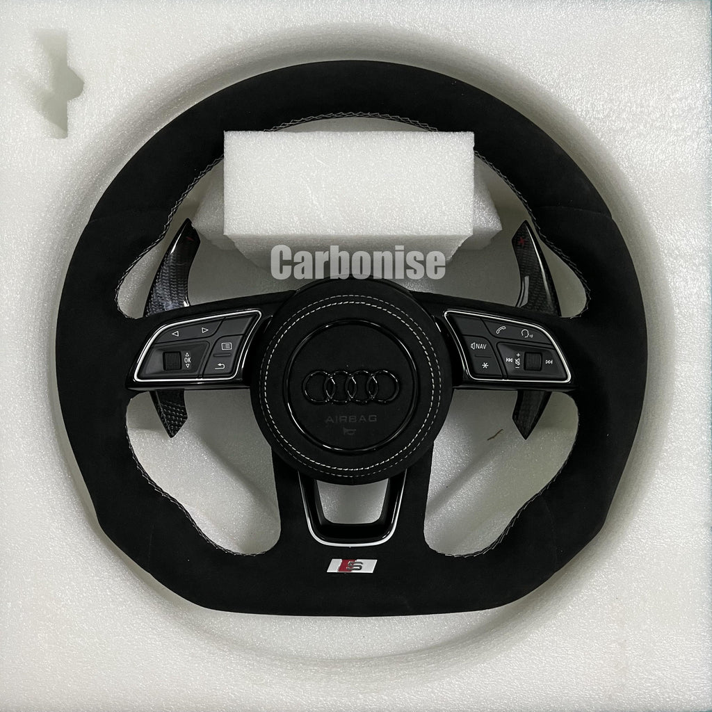 Custom Audi RS steering wheel fully wrapped in black Alcantara with white stitching, featuring gloss carbon fiber paddle shifters and a blacked-out center emblem.
