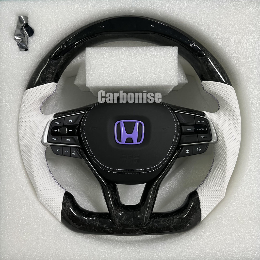 Custom Honda steering wheel featuring forged carbon top and bottom, white perforated leather side grips, purple Honda emblem, and OEM multifunction controls.