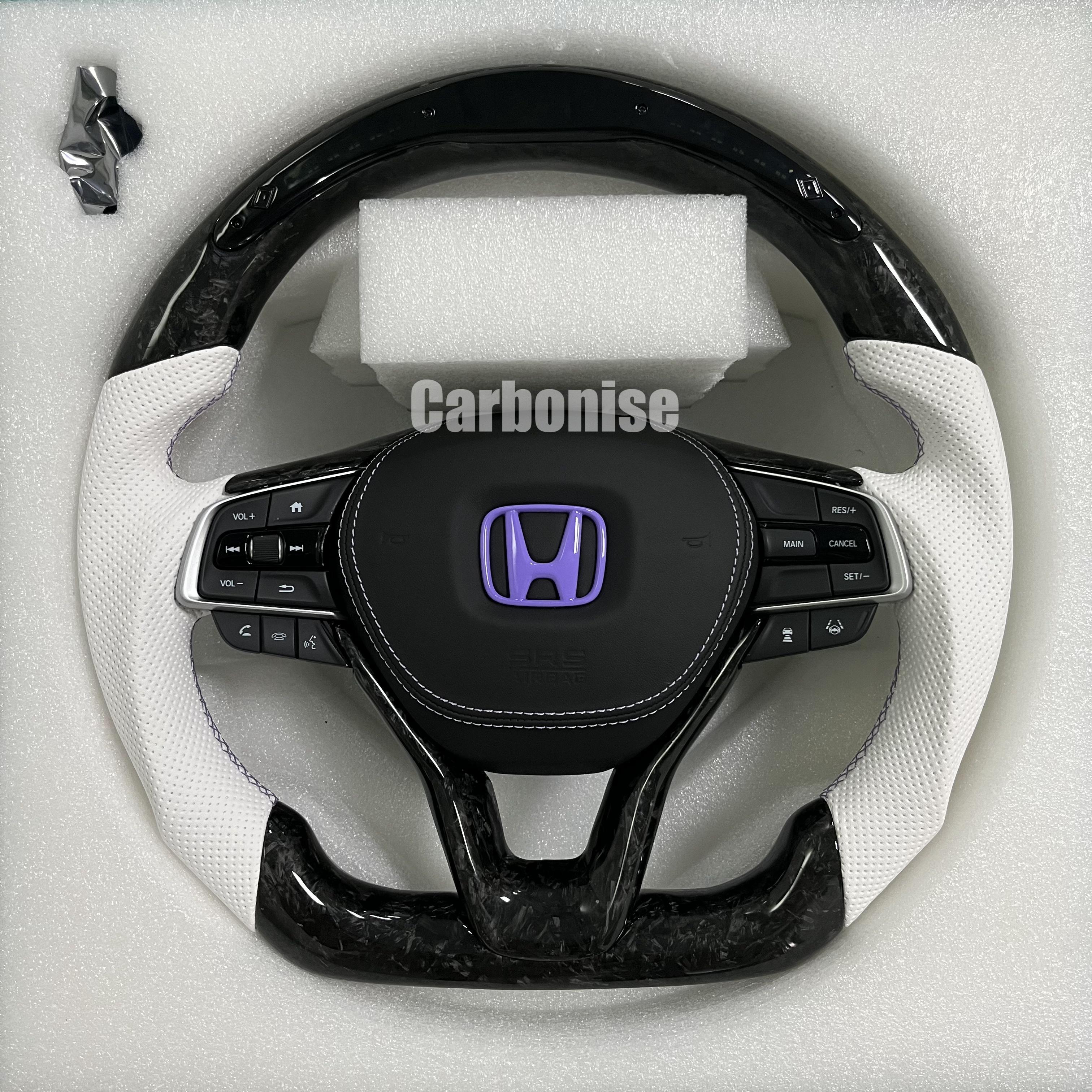 Custom Honda steering wheel featuring forged carbon top and bottom, white perforated leather side grips, purple Honda emblem, and OEM multifunction controls.