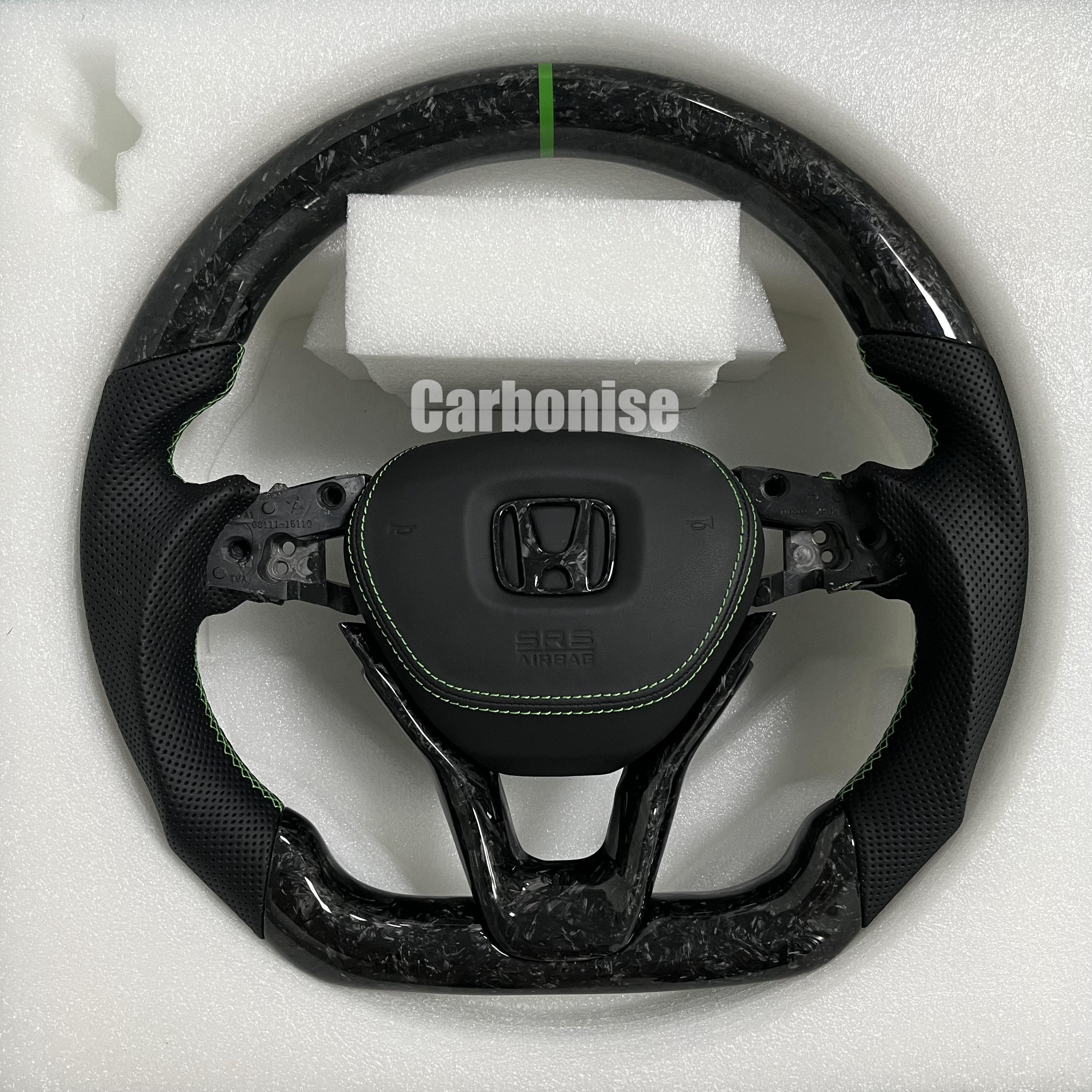 Custom Honda forged carbon steering wheel featuring a green center stripe, black perforated leather side grips, green stitching, and OEM Honda airbag mount.