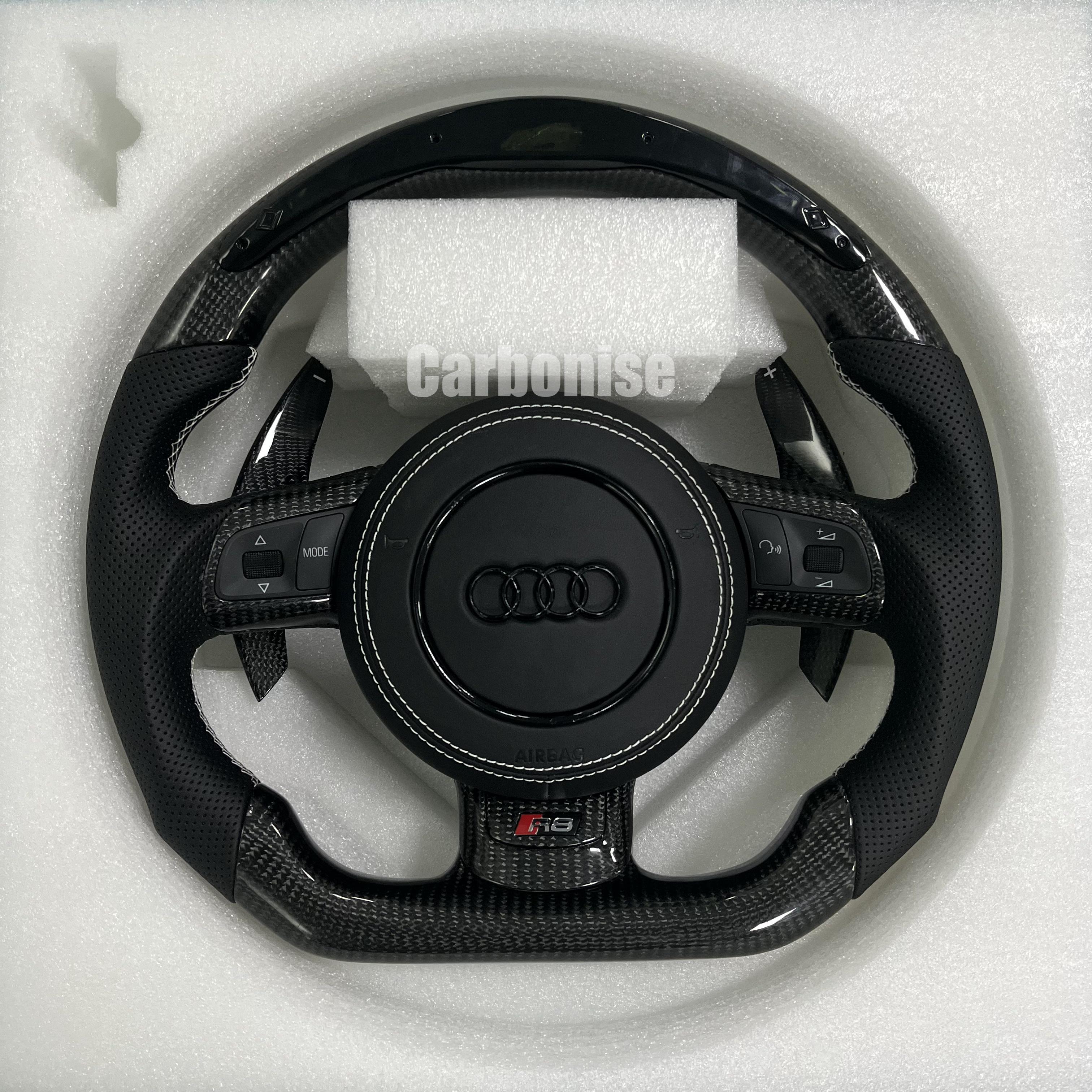 Custom Audi R8 steering wheel featuring gloss carbon fiber, integrated LED shift light display, carbon fiber paddle shifters, and perforated leather grips.