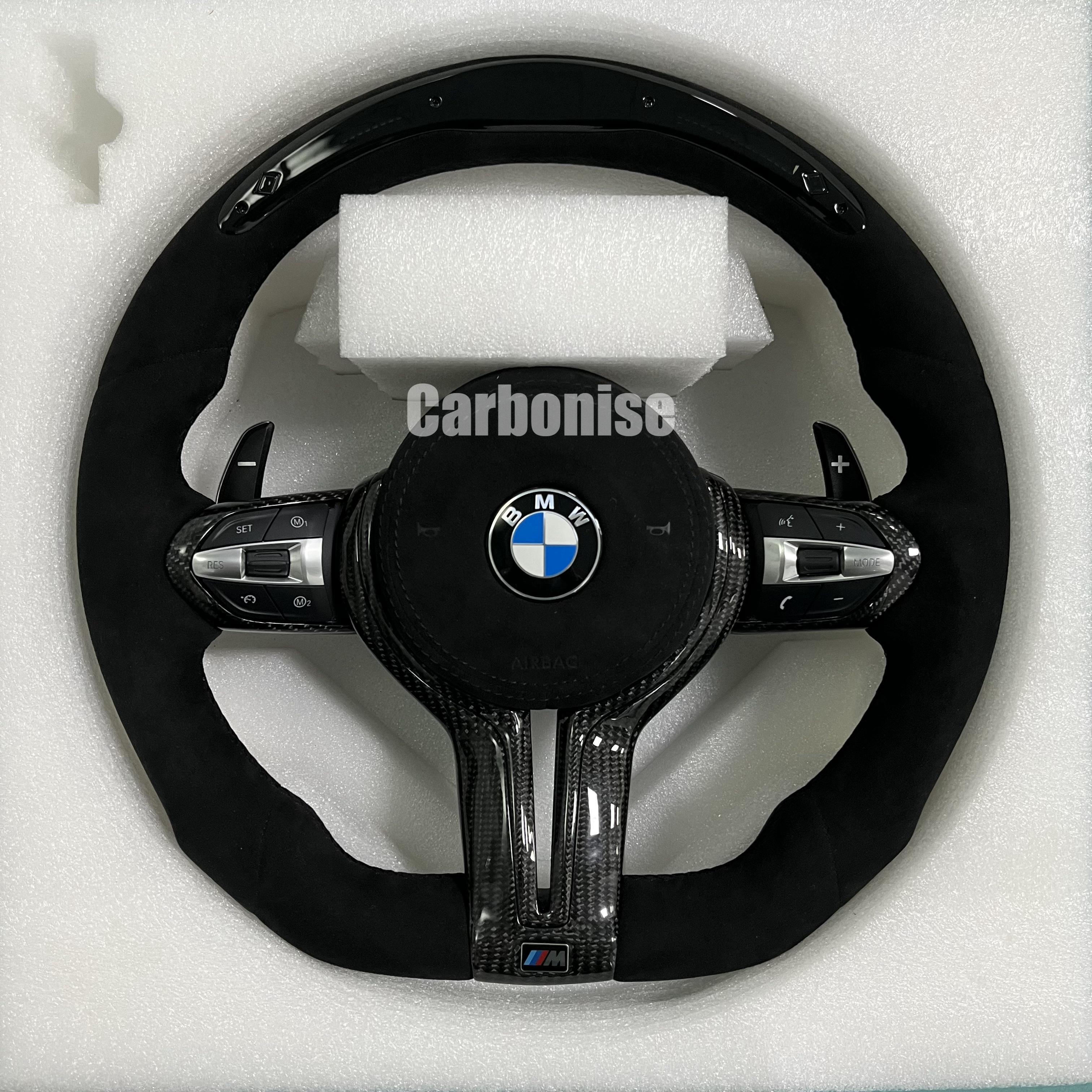 Custom BMW M Performance steering wheel featuring a full black Alcantara wrap, blue contrast stitching, and high-gloss twill carbon fiber trim on the top, bottom, and center spokes.