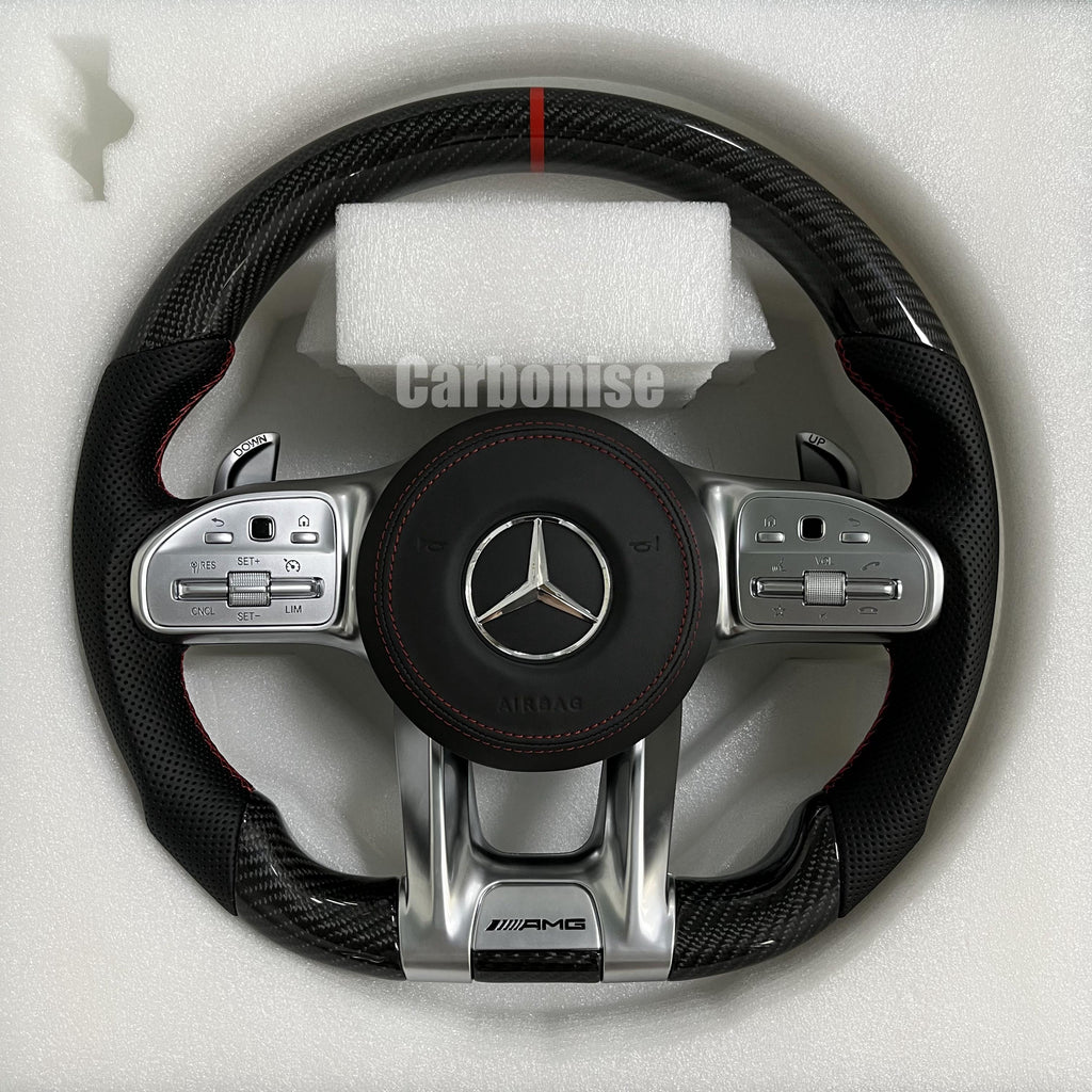 Custom Mercedes-Benz AMG steering wheel featuring high-gloss carbon fiber, a red top racing stripe, black perforated leather grips, and silver controls.