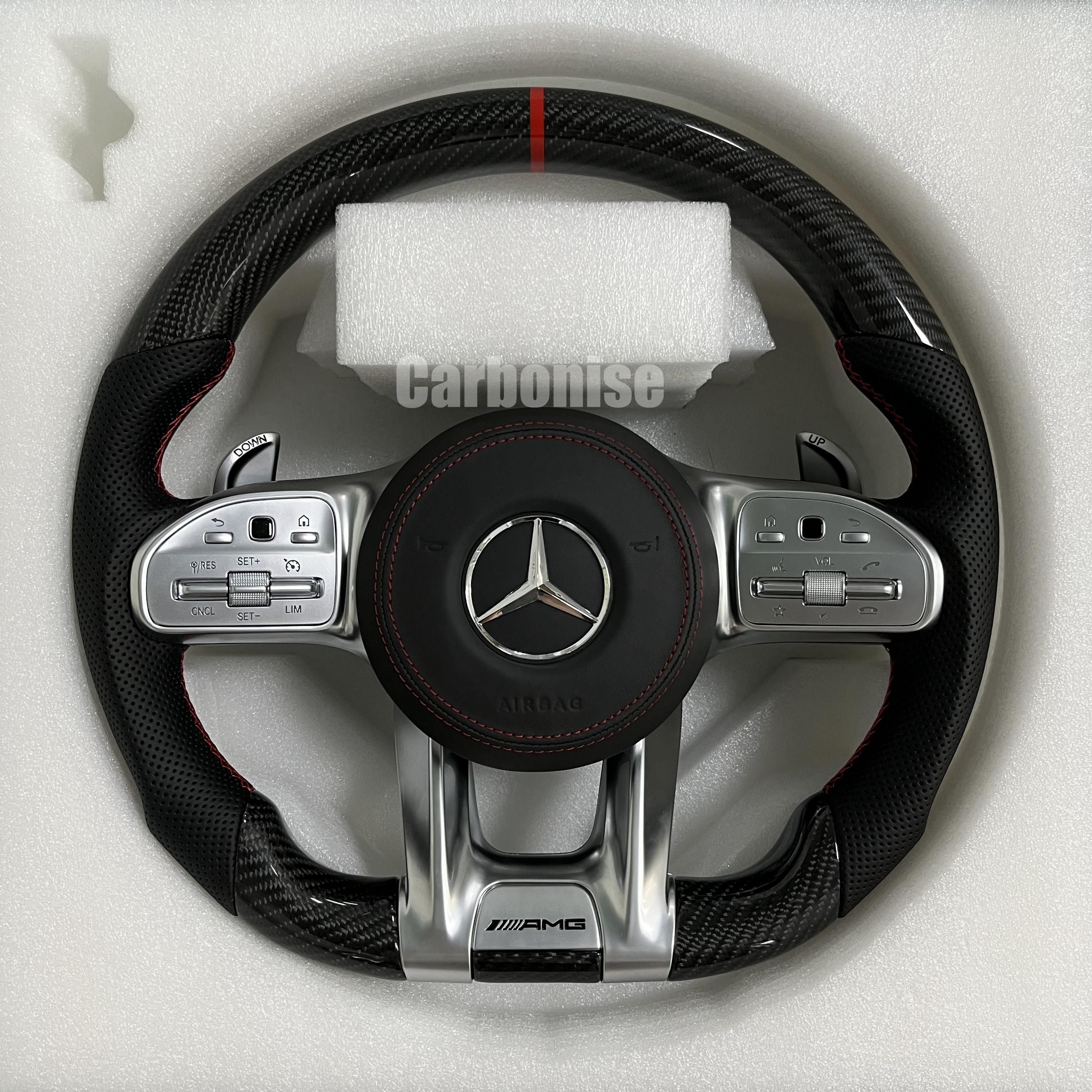 Custom Mercedes-Benz AMG steering wheel featuring high-gloss carbon fiber, a red top racing stripe, black perforated leather grips, and silver controls.