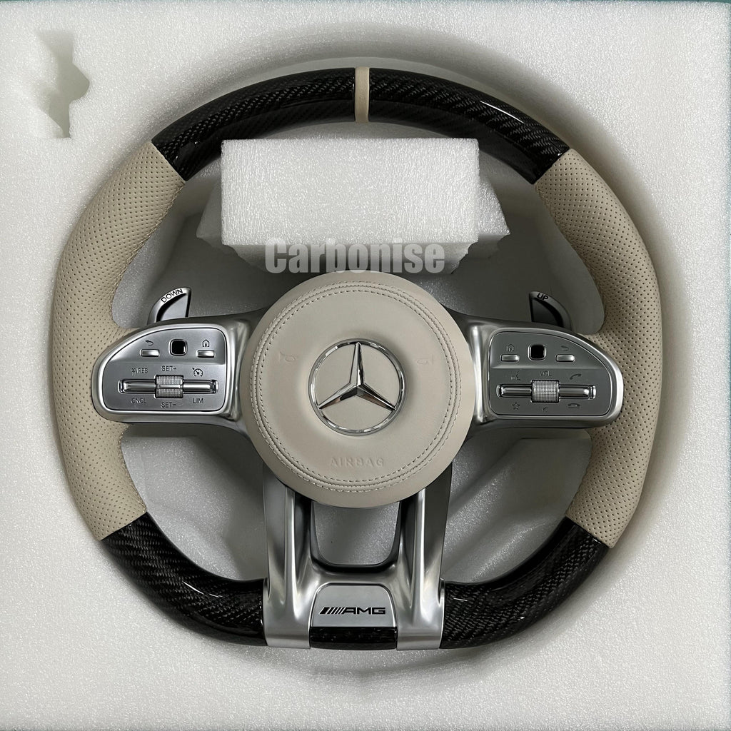 Custom Mercedes-Benz AMG performance steering wheel featuring high-gloss carbon fiber, a cream leather airbag cover, and matching cream perforated leather grips.

Final Master Performance Series: Merce