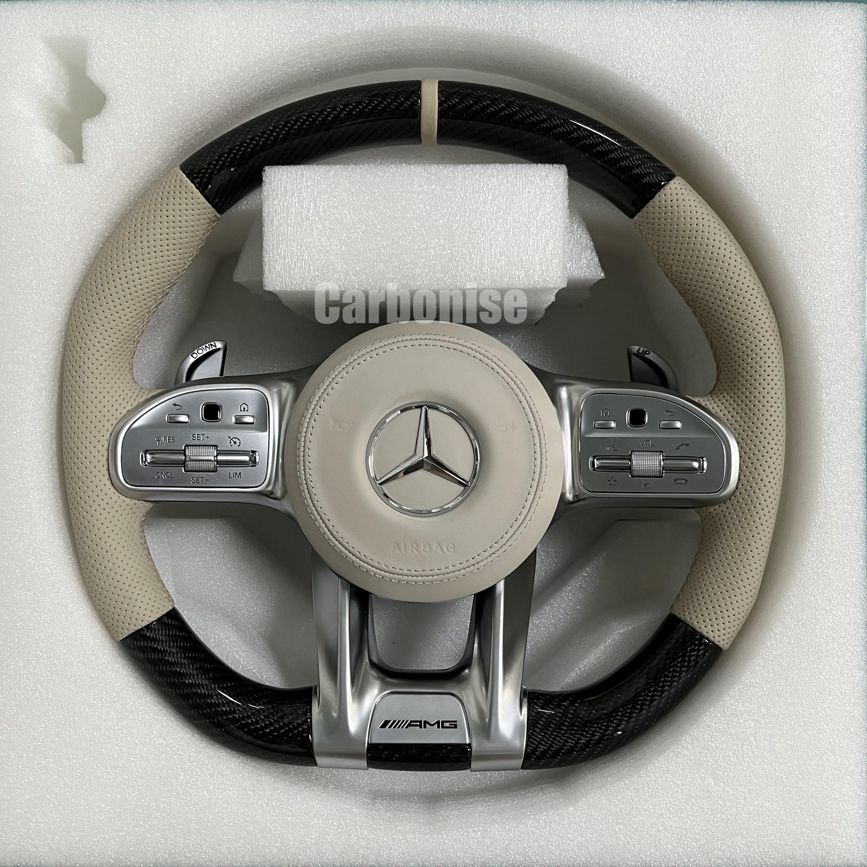 Custom Mercedes-Benz AMG performance steering wheel featuring high-gloss carbon fiber, a cream leather airbag cover, and matching cream perforated leather grips.

Final Master Performance Series: Merce