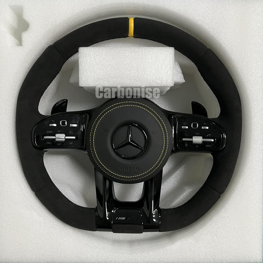 Custom Mercedes-Benz AMG performance steering wheel featuring a full black Alcantara wrap, a yellow top racing stripe, and matching yellow stitching on the airbag cover.
