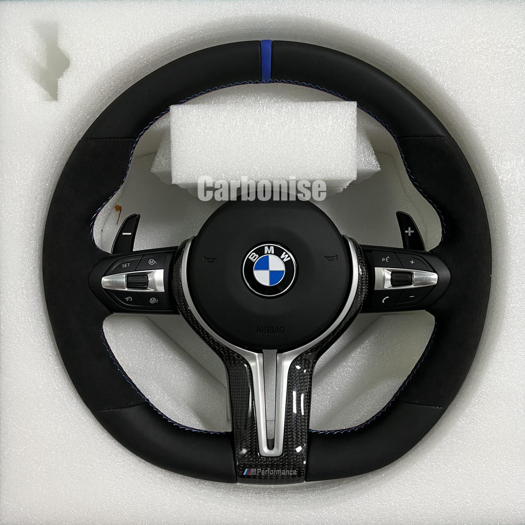 Custom BMW M performance steering wheel featuring black Alcantara grips, smooth leather top and bottom sections, and a blue racing stripe.