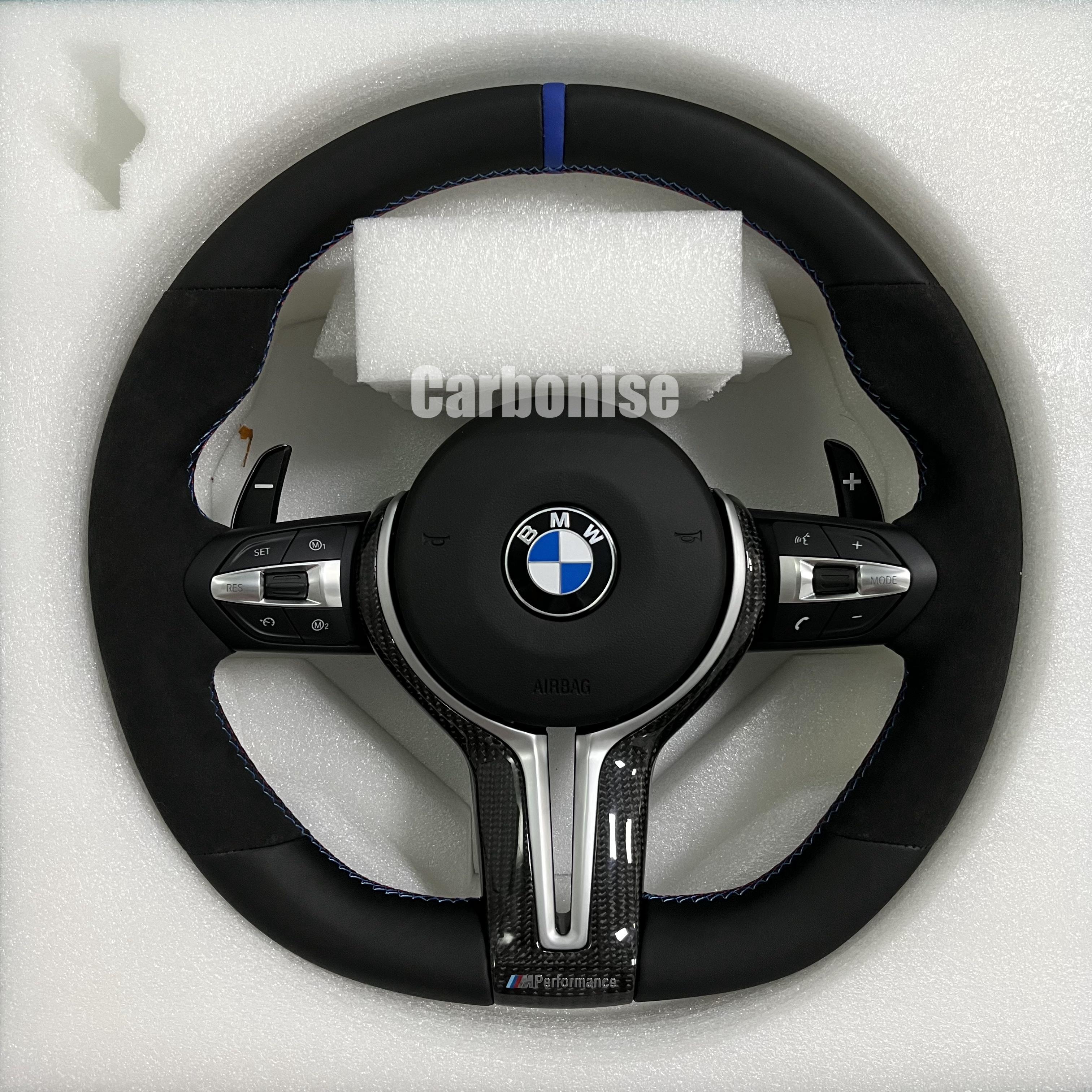 Custom BMW M performance steering wheel featuring black Alcantara grips, smooth leather top and bottom sections, and a blue racing stripe.