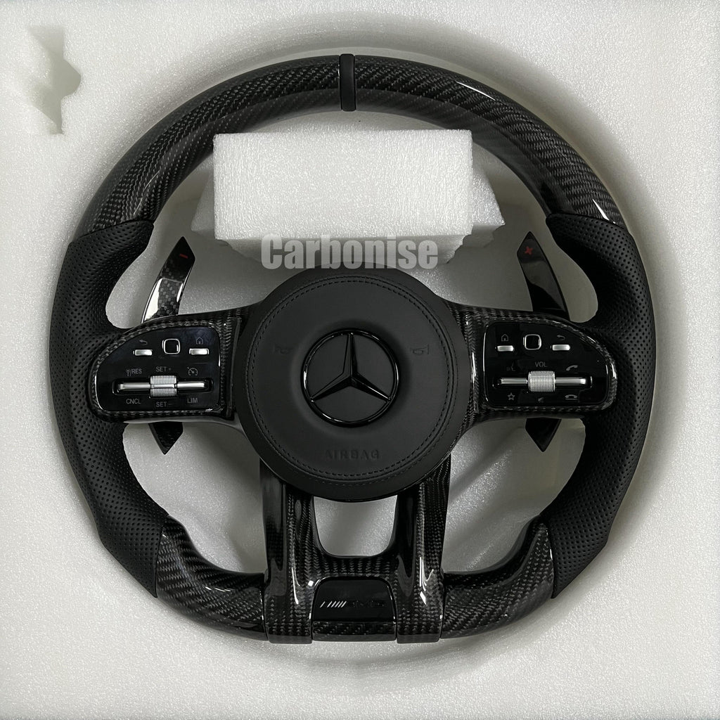 Custom Mercedes-Benz AMG steering wheel featuring gloss carbon fiber, black perforated leather side grips, and a subtle black top racing stripe.