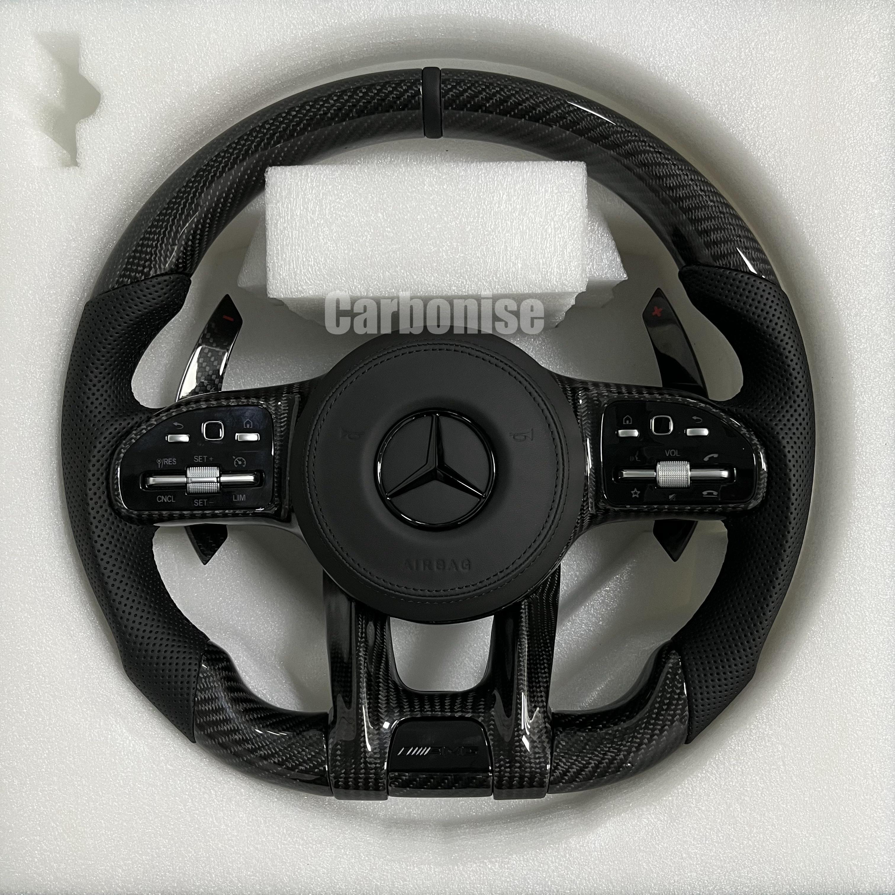 Custom Mercedes-Benz AMG steering wheel featuring gloss carbon fiber, black perforated leather side grips, and a subtle black top racing stripe.