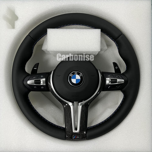 BMW M Performance steering wheel featuring a full black smooth leather wrap, blue contrast stitching, and a high-gloss carbon fiber bottom spoke trim.
