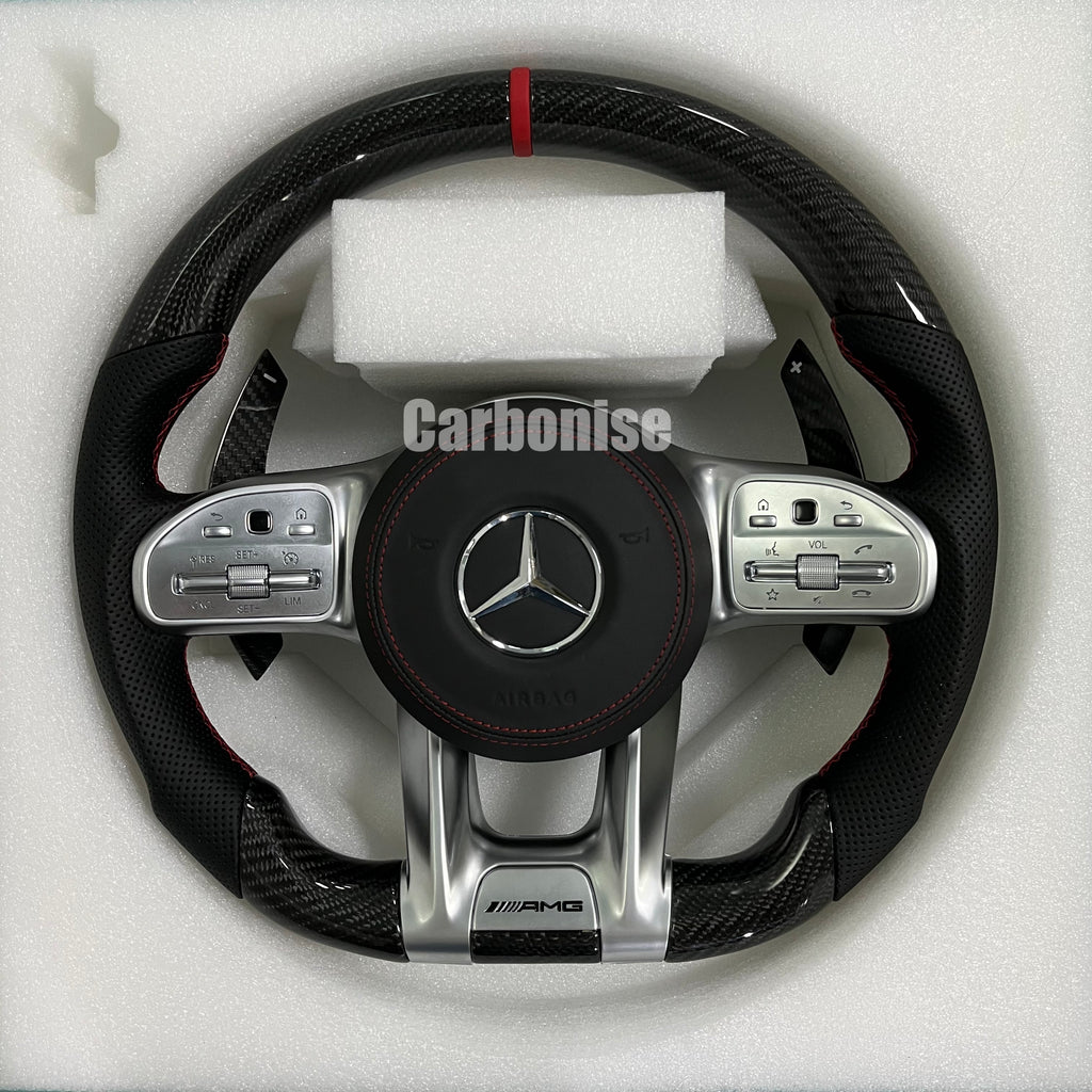 Custom Mercedes-Benz AMG steering wheel featuring high-gloss carbon fiber, a red top racing stripe, black perforated leather grips, and silver controls.