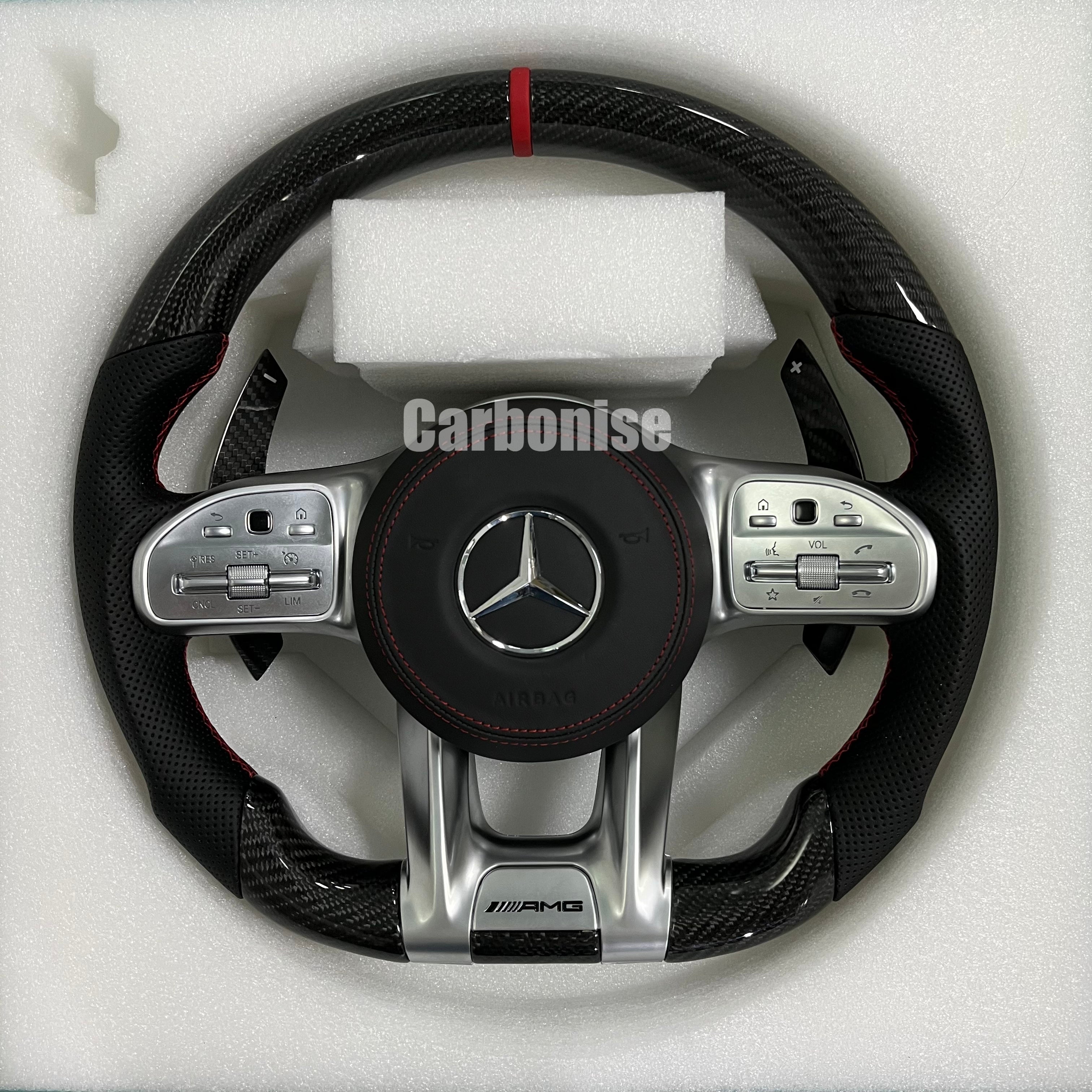 Custom Mercedes-Benz AMG steering wheel featuring high-gloss carbon fiber, a red top racing stripe, black perforated leather grips, and silver controls.