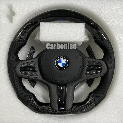Custom BMW M performance steering wheel featuring high-gloss carbon fiber, a blue top racing stripe, and black perforated leather grips with blue stitching.