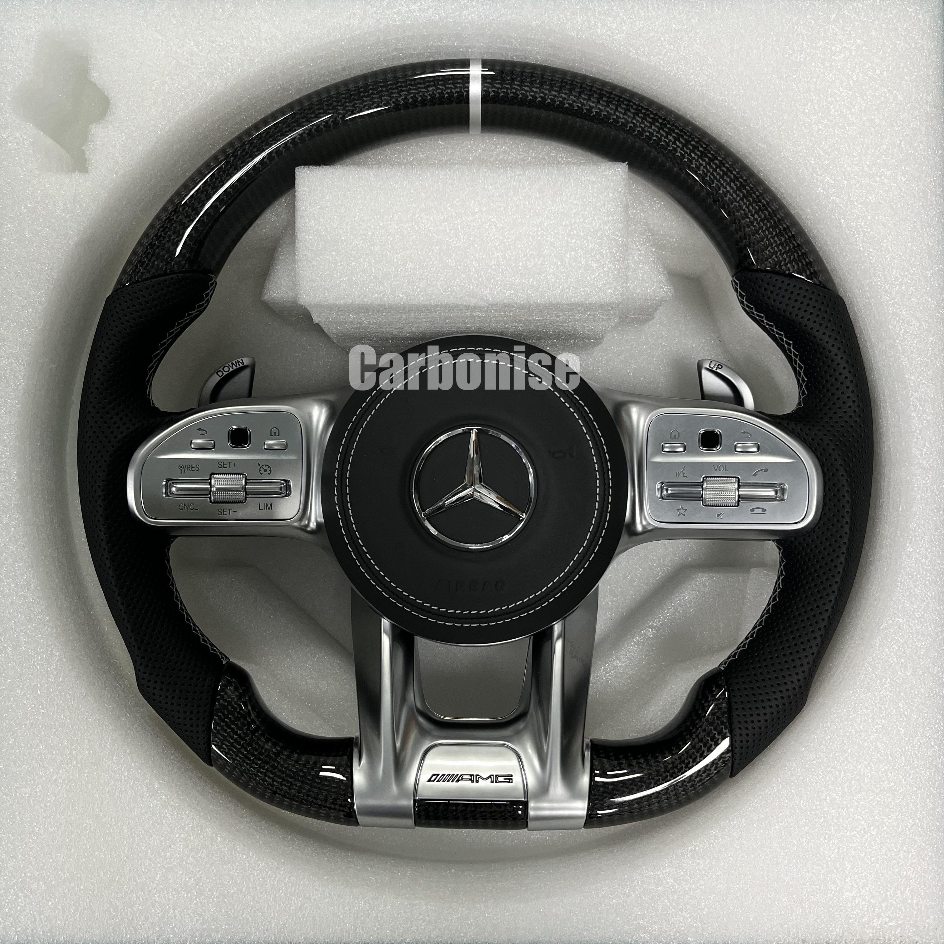 Custom Mercedes-Benz AMG steering wheel featuring high-gloss carbon fiber, a silver top racing stripe, and black perforated leather side grips.