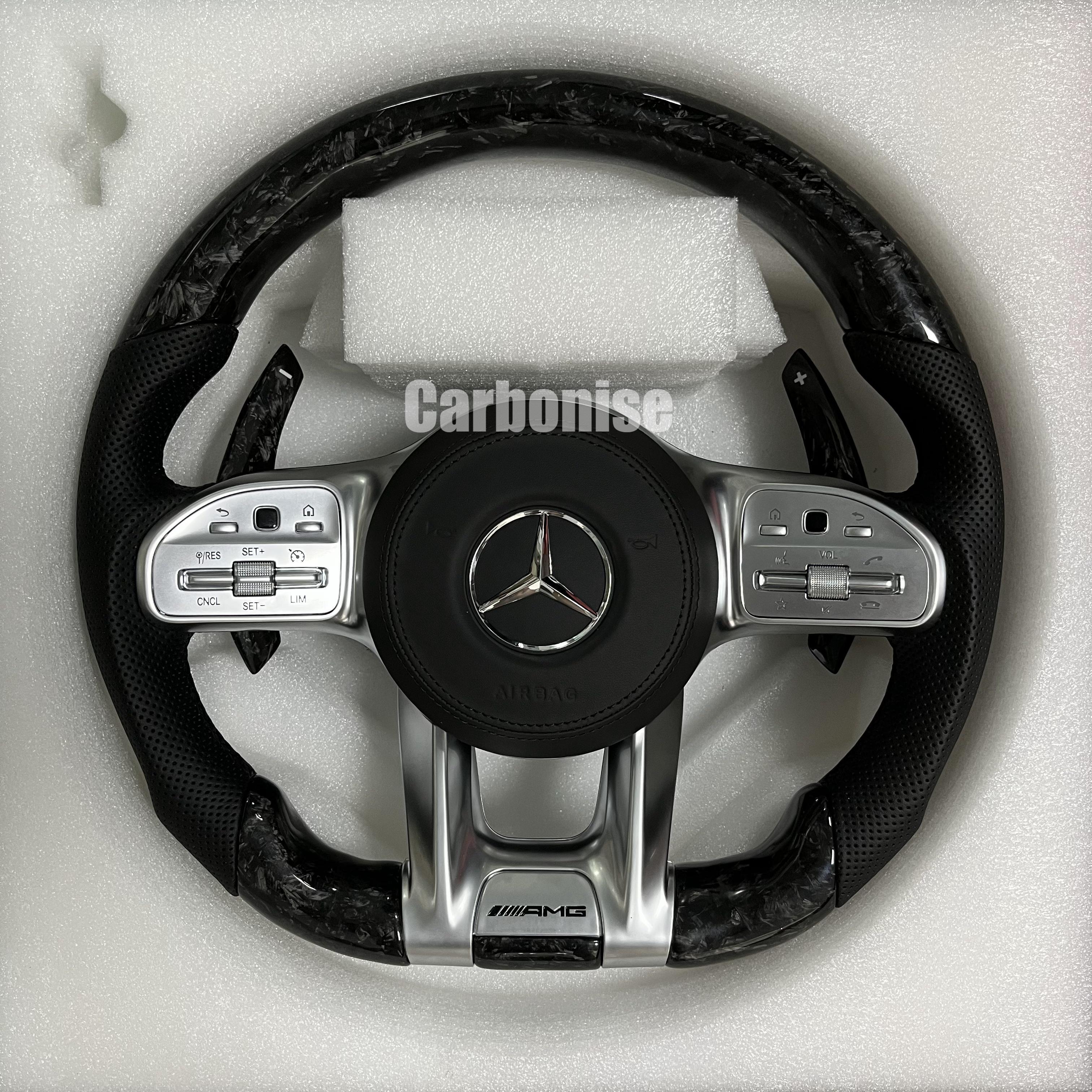 Custom Mercedes-Benz AMG steering wheel featuring a forged carbon fiber marbled finish, black perforated leather grips, and integrated silver controls.