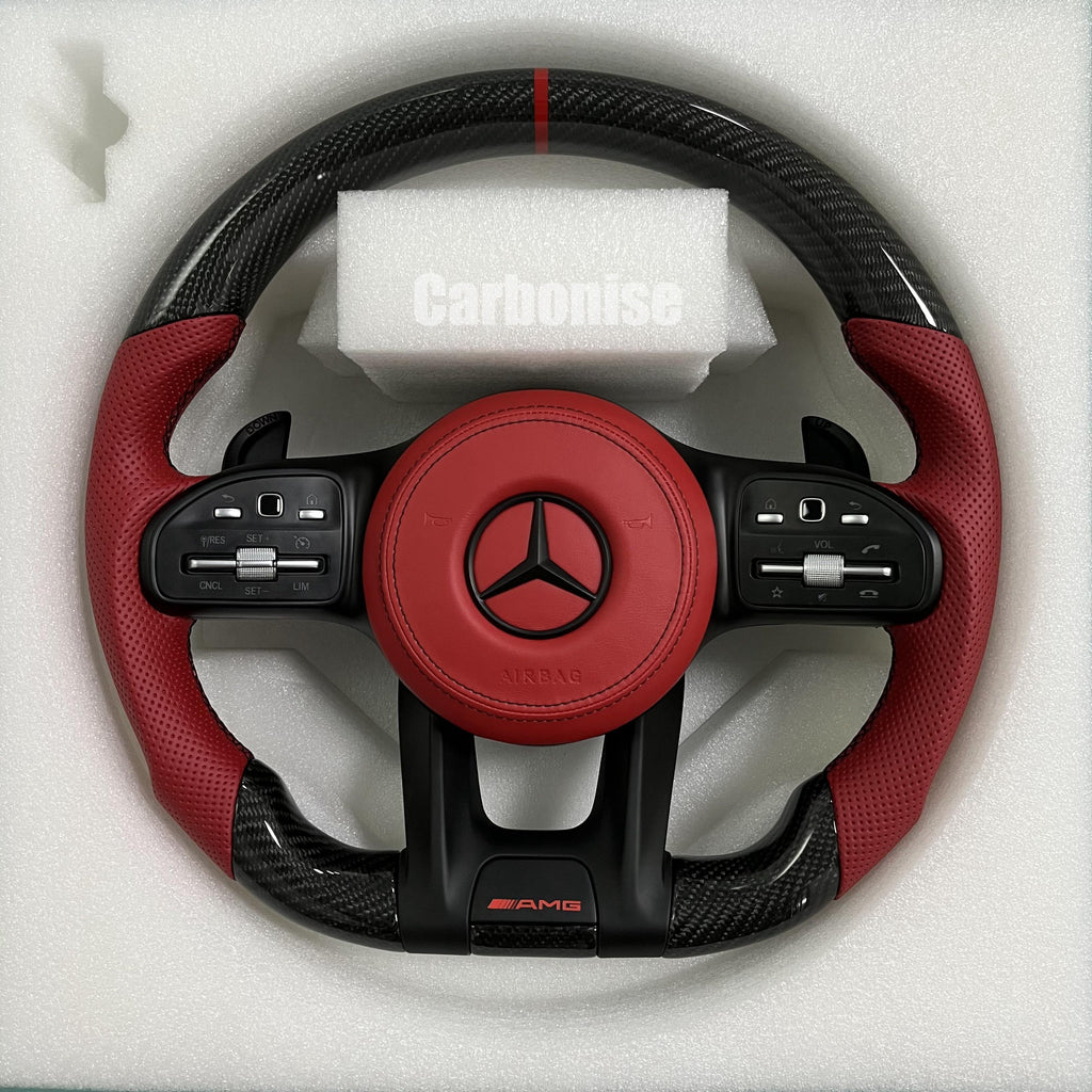 Custom Mercedes-Benz AMG steering wheel featuring gloss carbon fiber, a vibrant red leather airbag cover, and matching red perforated leather grips.