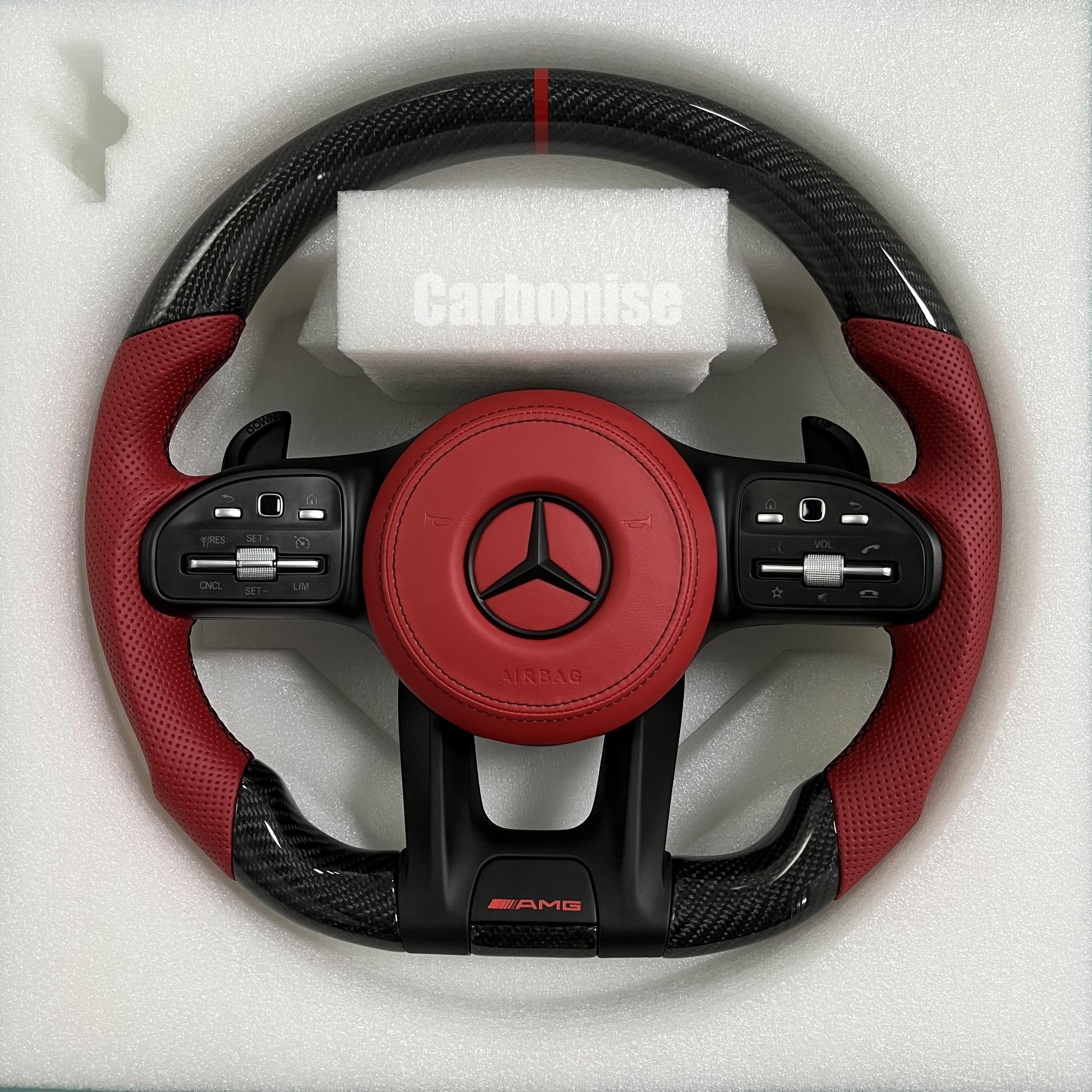 Custom Mercedes-Benz AMG steering wheel featuring gloss carbon fiber, a vibrant red leather airbag cover, and matching red perforated leather grips.