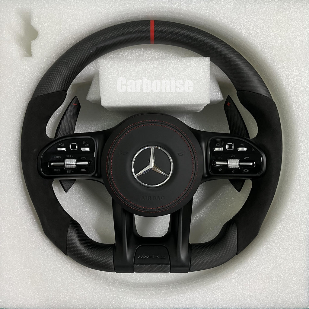 Custom Mercedes-Benz AMG steering wheel featuring a matte carbon fiber finish, black Alcantara side grips, and a vibrant red top racing stripe.
