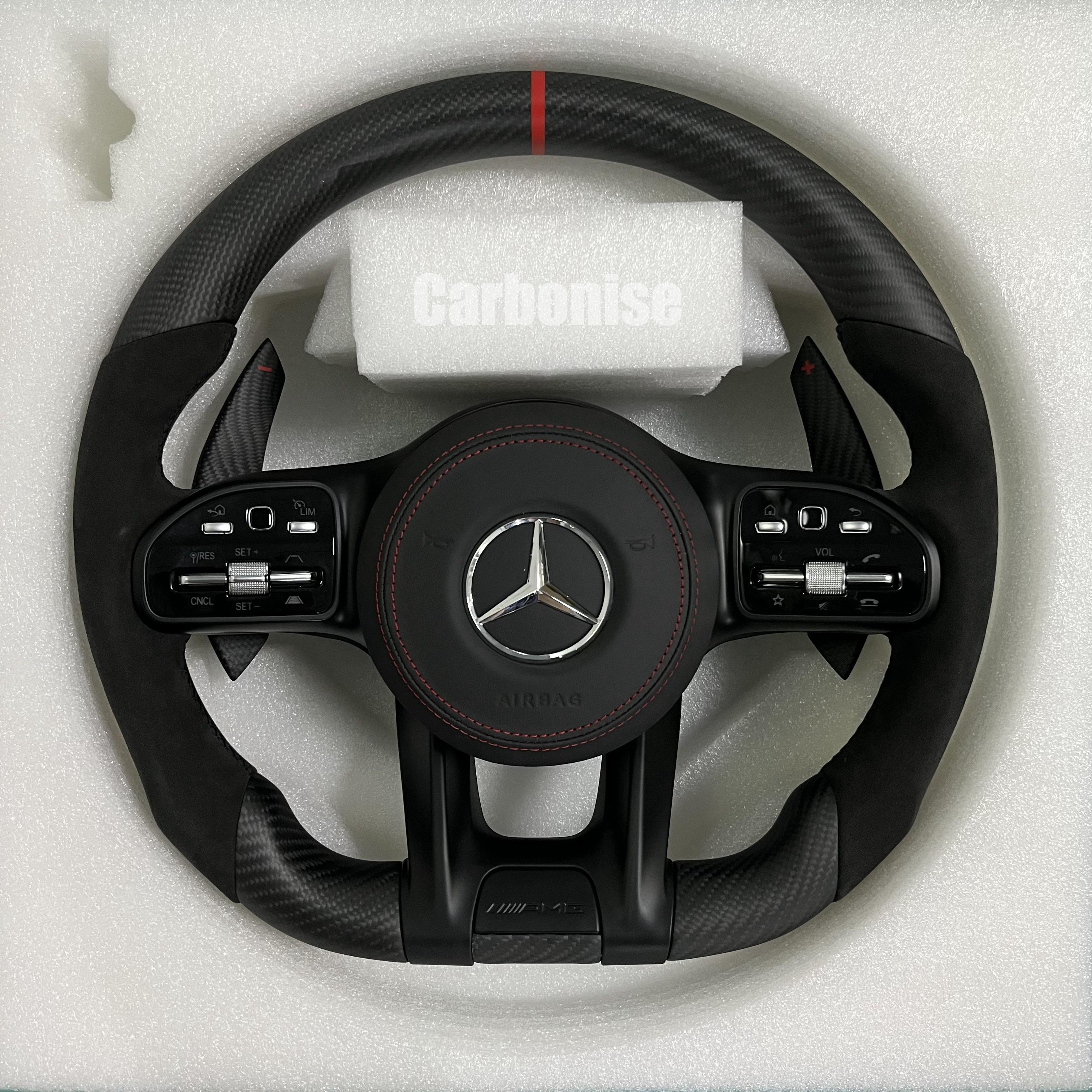 Custom Mercedes-Benz AMG steering wheel featuring a matte carbon fiber finish, black Alcantara side grips, and a vibrant red top racing stripe.