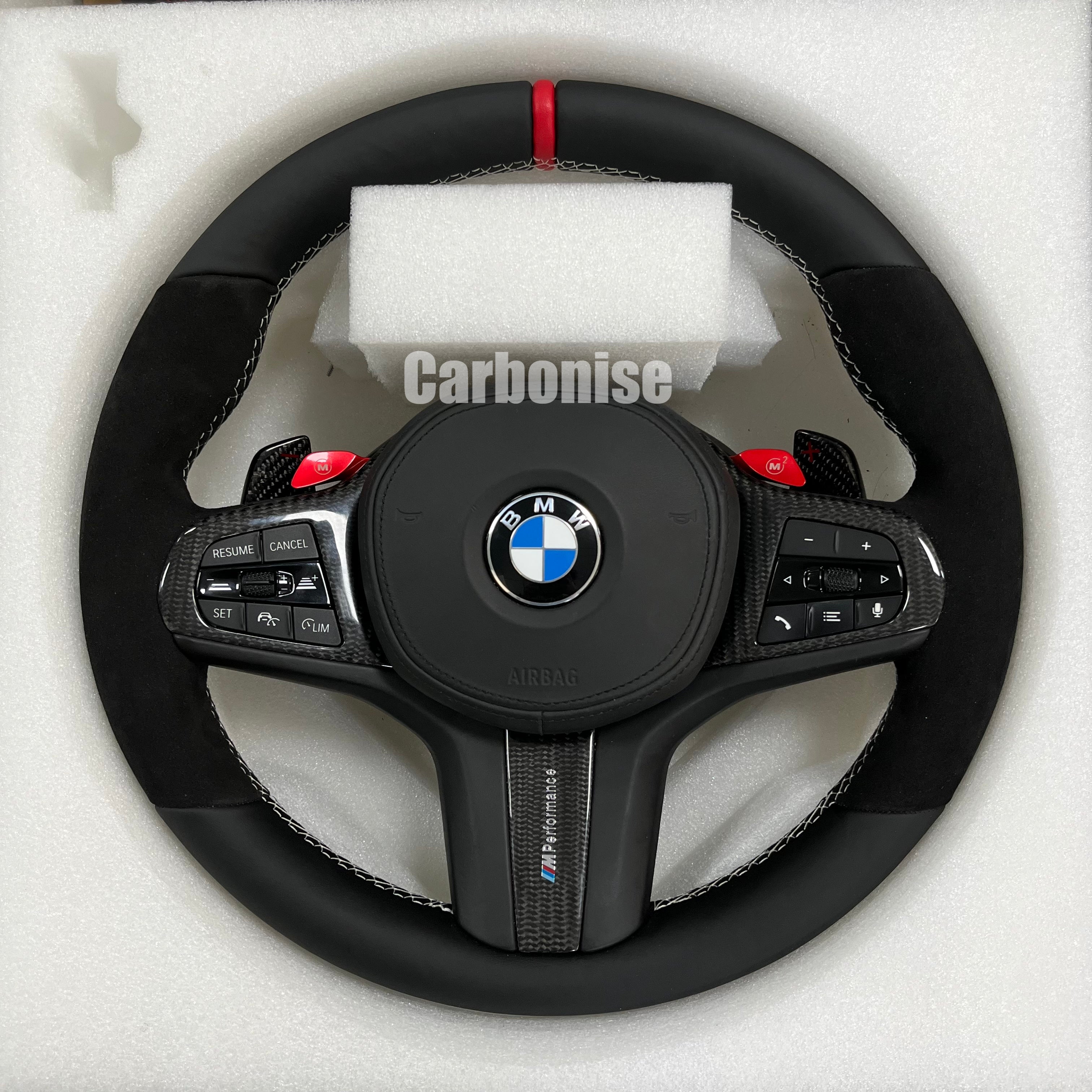 Custom BMW M performance steering wheel featuring black Alcantara grips, smooth leather top and bottom, a red racing stripe, and red M1/M2 button accents.