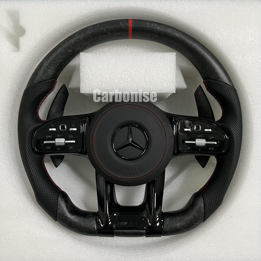 Custom Mercedes-Benz AMG steering wheel featuring matte forged carbon fiber, a red top racing stripe, and black perforated leather grips with red stitching.