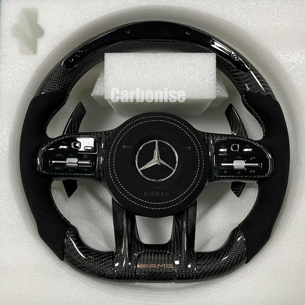 Custom Mercedes-Benz AMG steering wheel featuring high-gloss carbon fiber, a black Alcantara airbag cover, and matching black Alcantara side grips.
