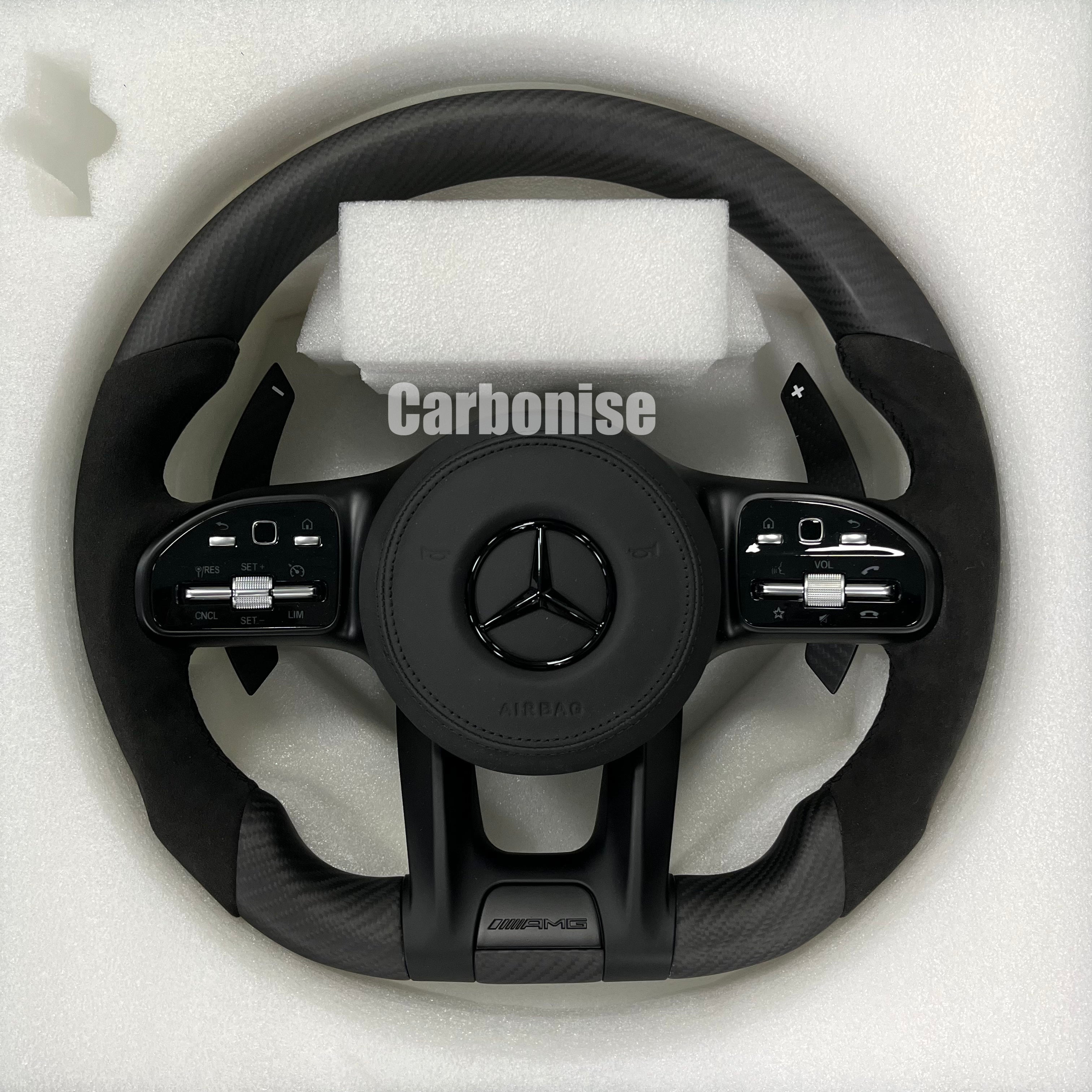 Custom Mercedes-Benz AMG performance steering wheel featuring a matte carbon fiber finish, black Alcantara side grips, and integrated stealth black controls.