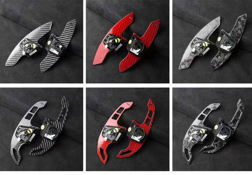 Extended carbon fibre paddle shifters in multiple finishes including gloss carbon, forged carbon, red forged carbon, and grey forged carbon.