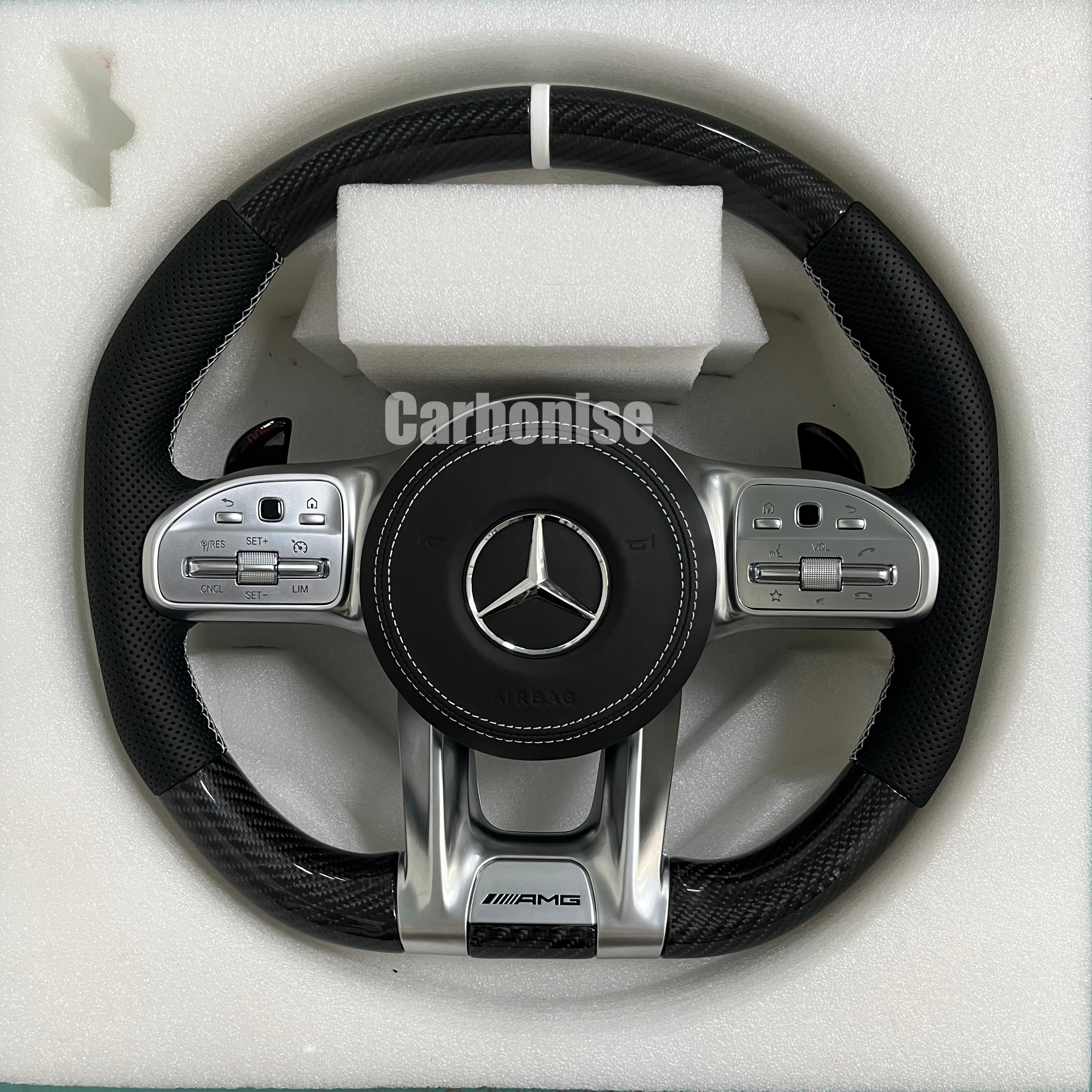 Custom Mercedes-Benz AMG steering wheel featuring gloss carbon fiber, black perforated leather side grips with white stitching, and a clean silver top racing stripe.
