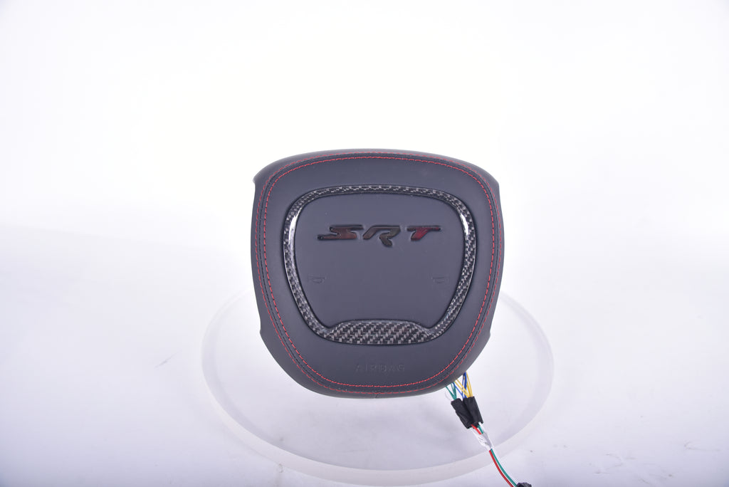 SRT carbon fibre airbag cover with black leather finish, red stitching, carbon fibre trim insert, and embossed SRT logo.
