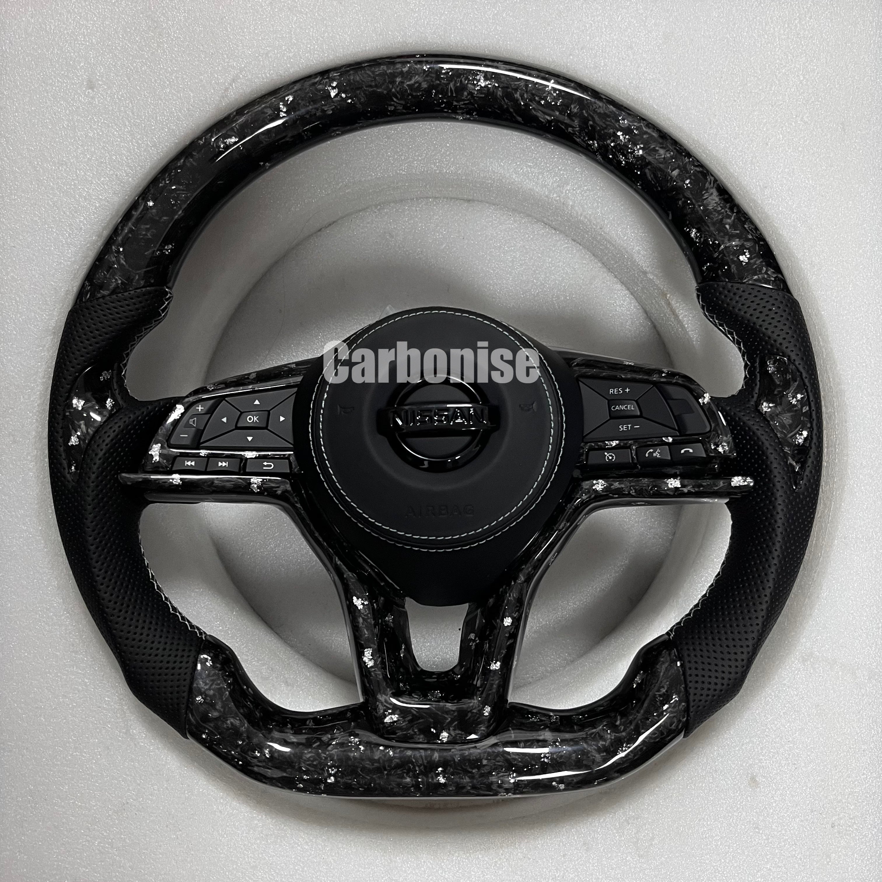 Carbonise Nissan forged carbon steering wheel with perforated leather grips and flat bottom design